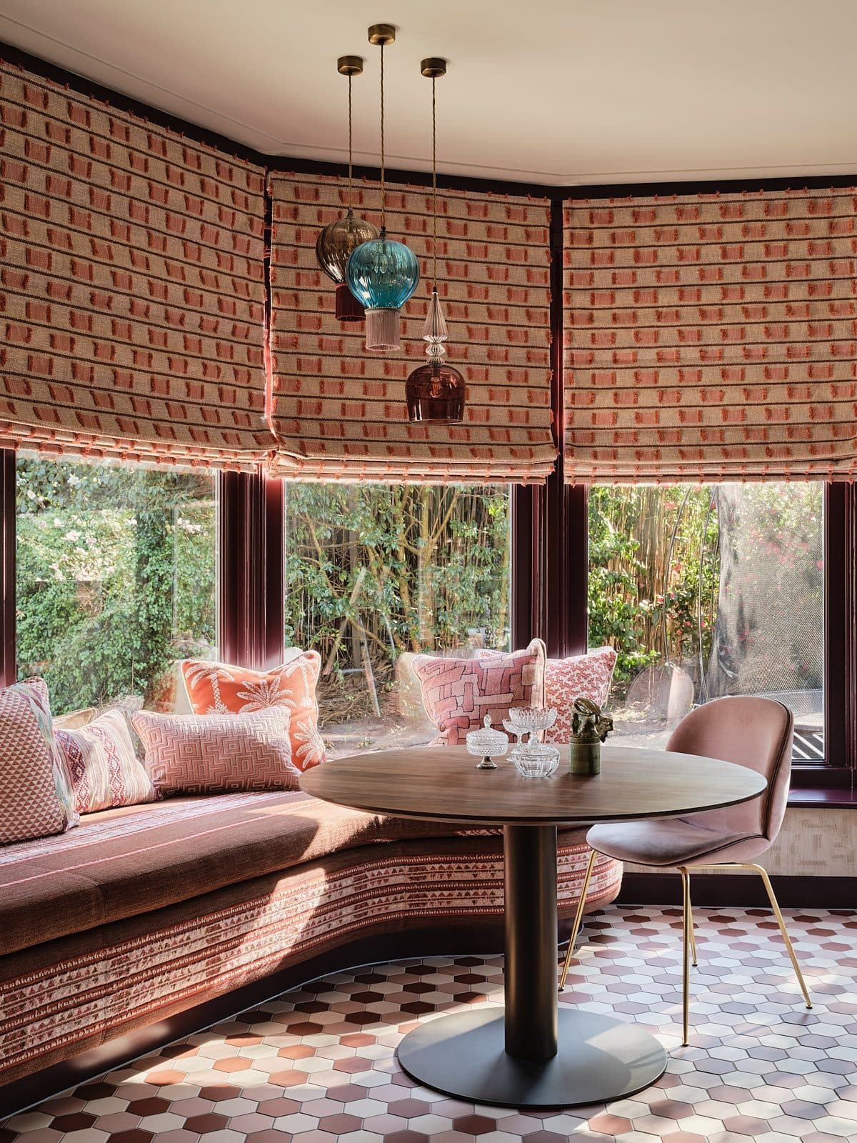 Woonkamer met terracotta muren, blauwe hoekbank en houten details