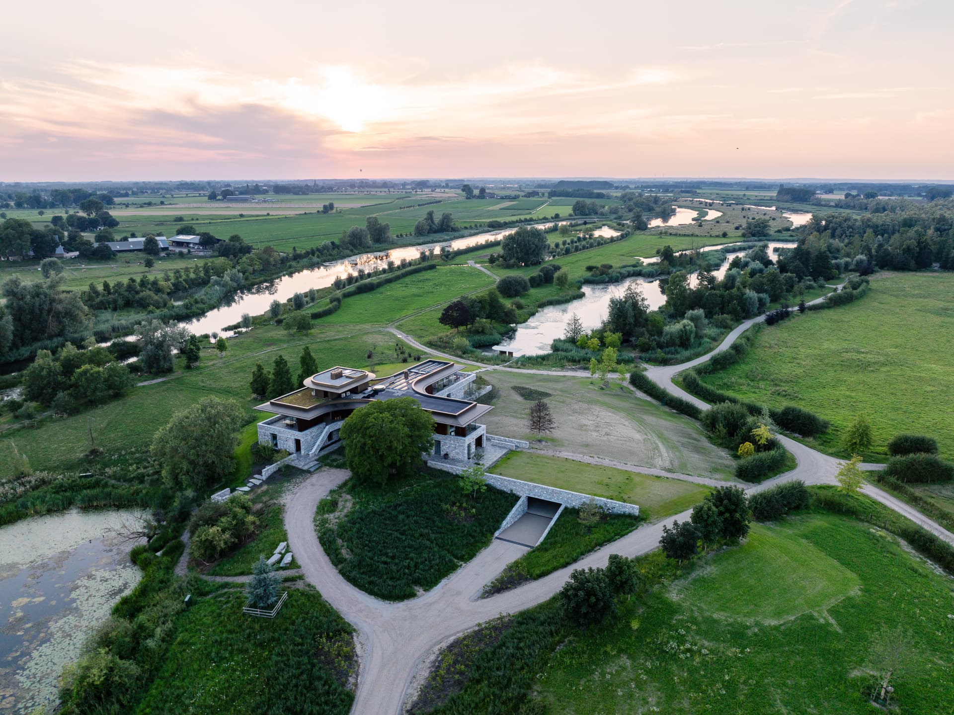 Luchtfoto van moderne villa met curved oprit aan rivier