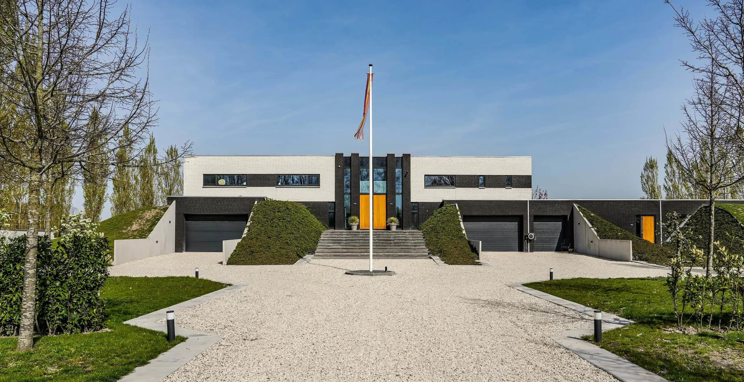 Moderne uitgravingsmonument met witte betonnen gevel en centraal trappenhuisgedeelte
