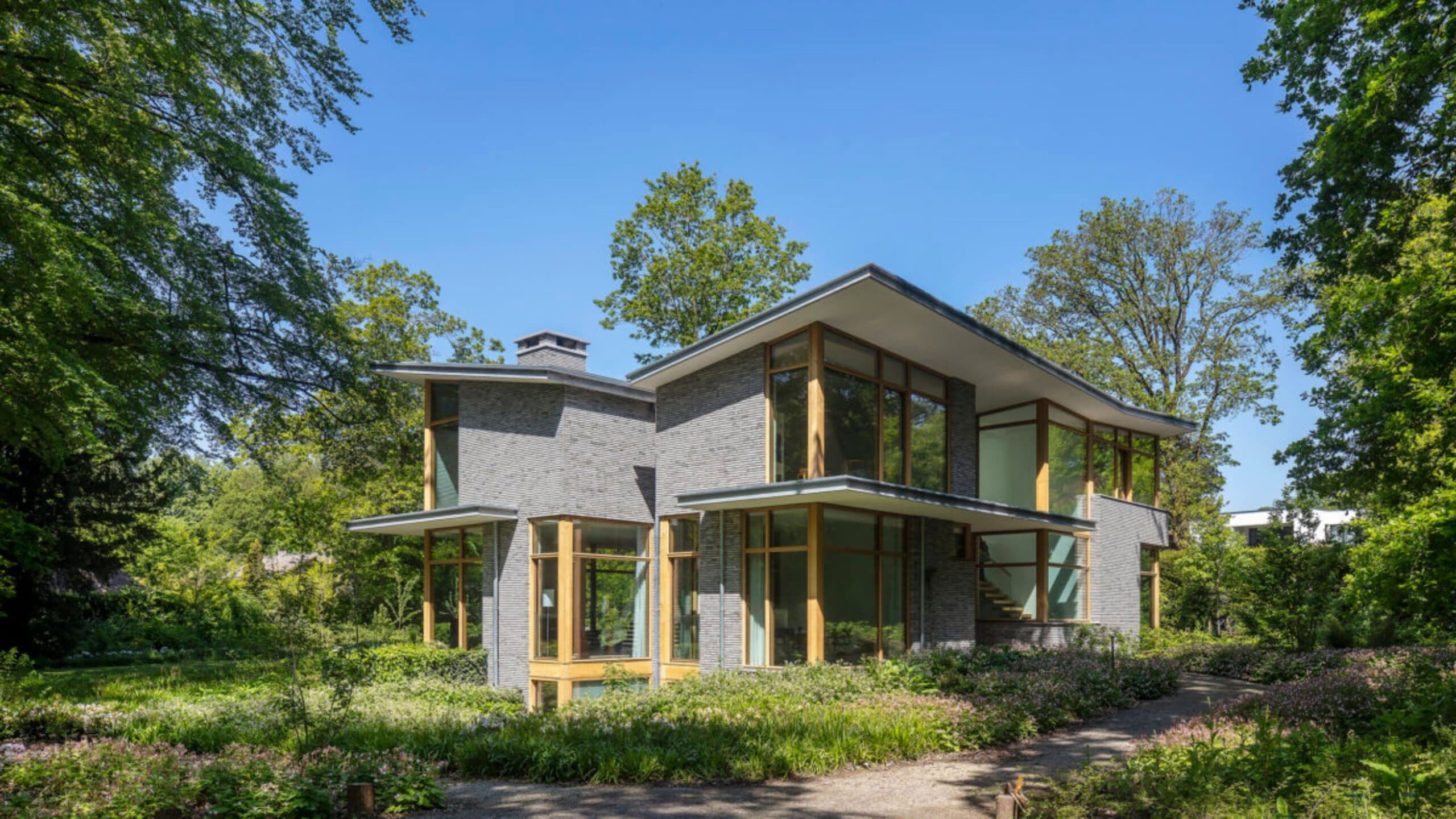 Hedendaagse villa met baksteengevel, houten accenten en natuurlijke omgeving