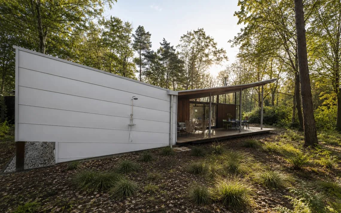 Moderne bungalow met wit gevelwerk, houten lamellen en open carport