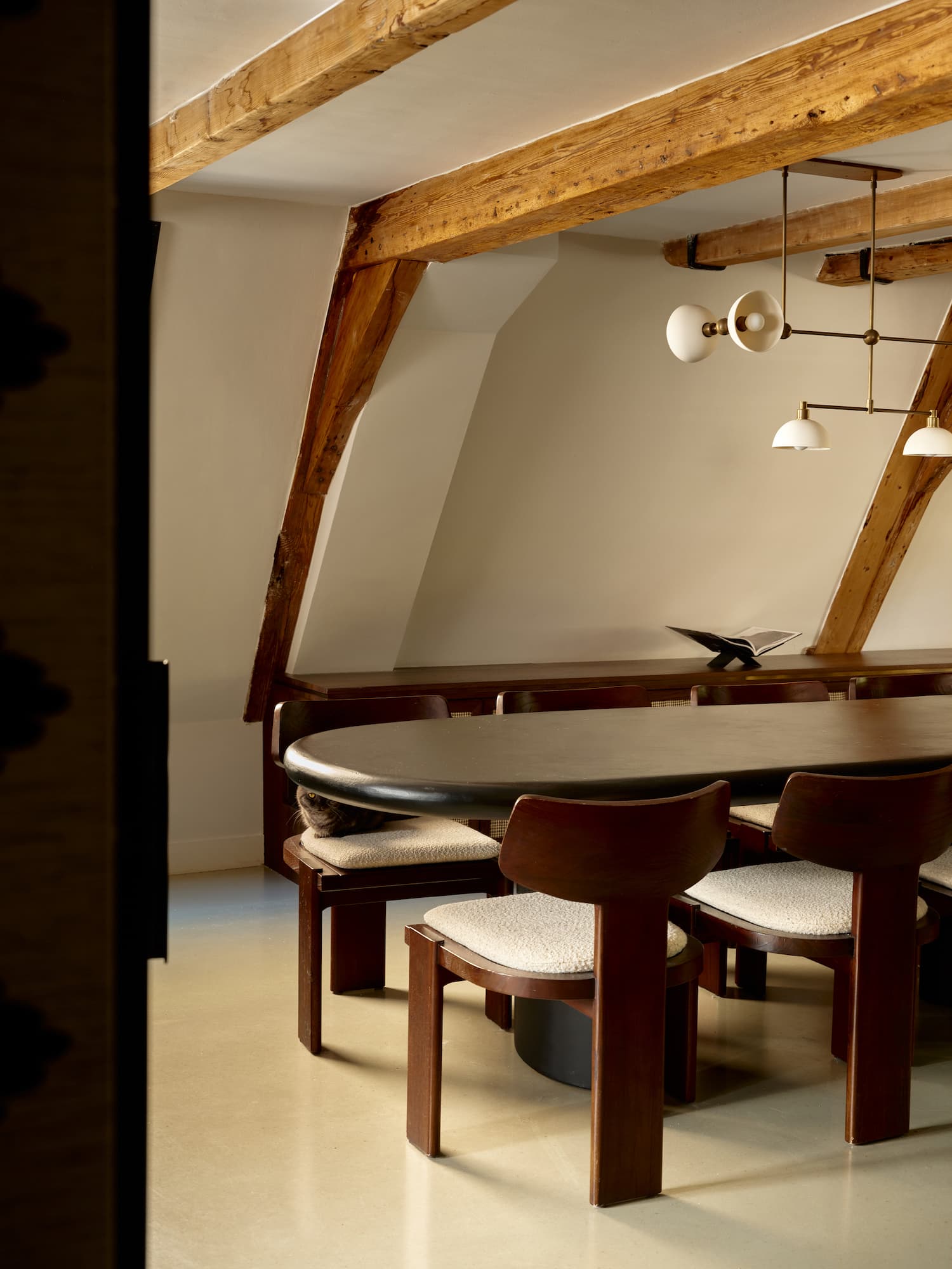 Eetkamer onder eiken spanten met houten stoelen