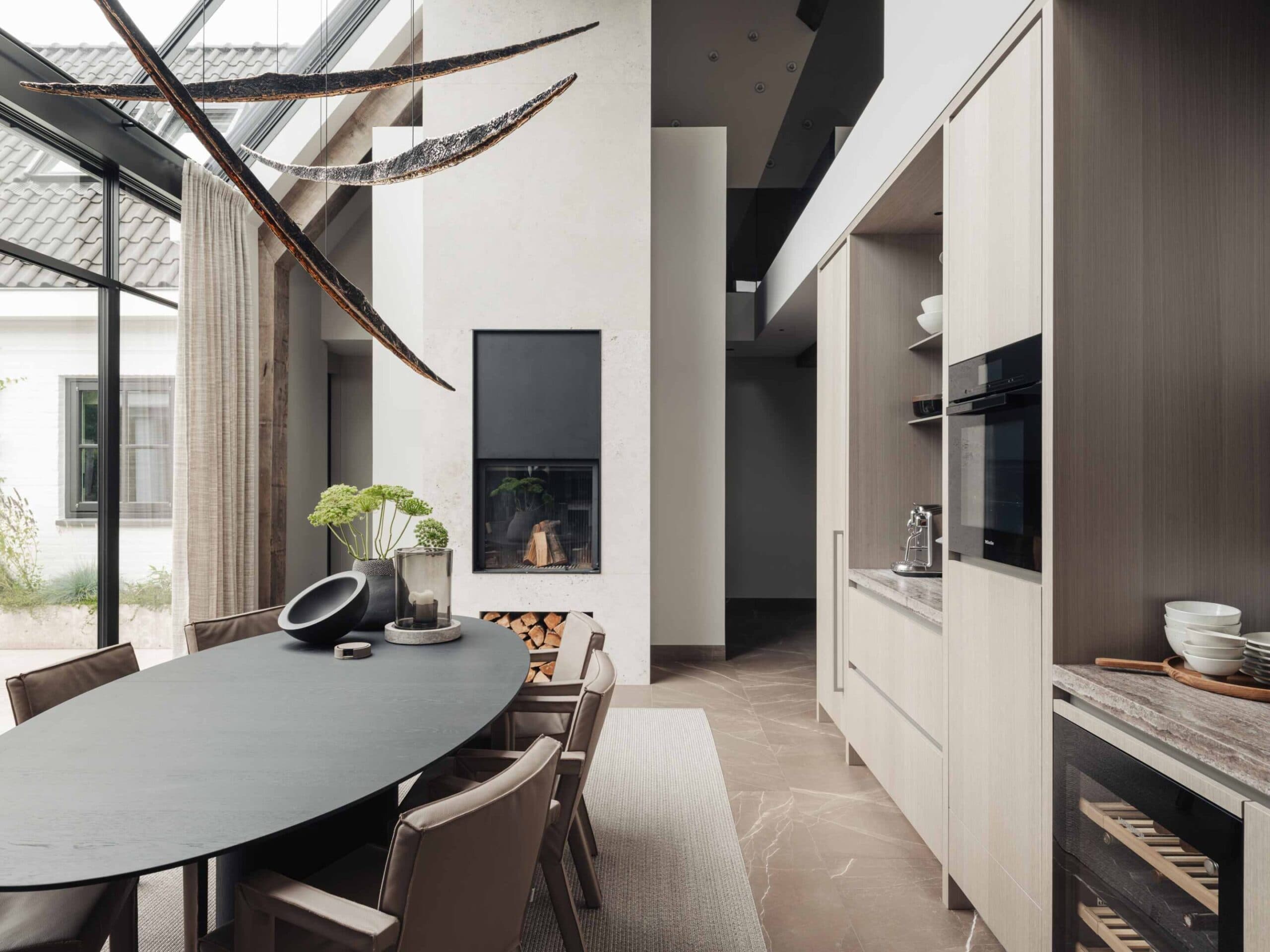 Moderne keuken met witte kasten, zwart fornuis en ronde eettafel