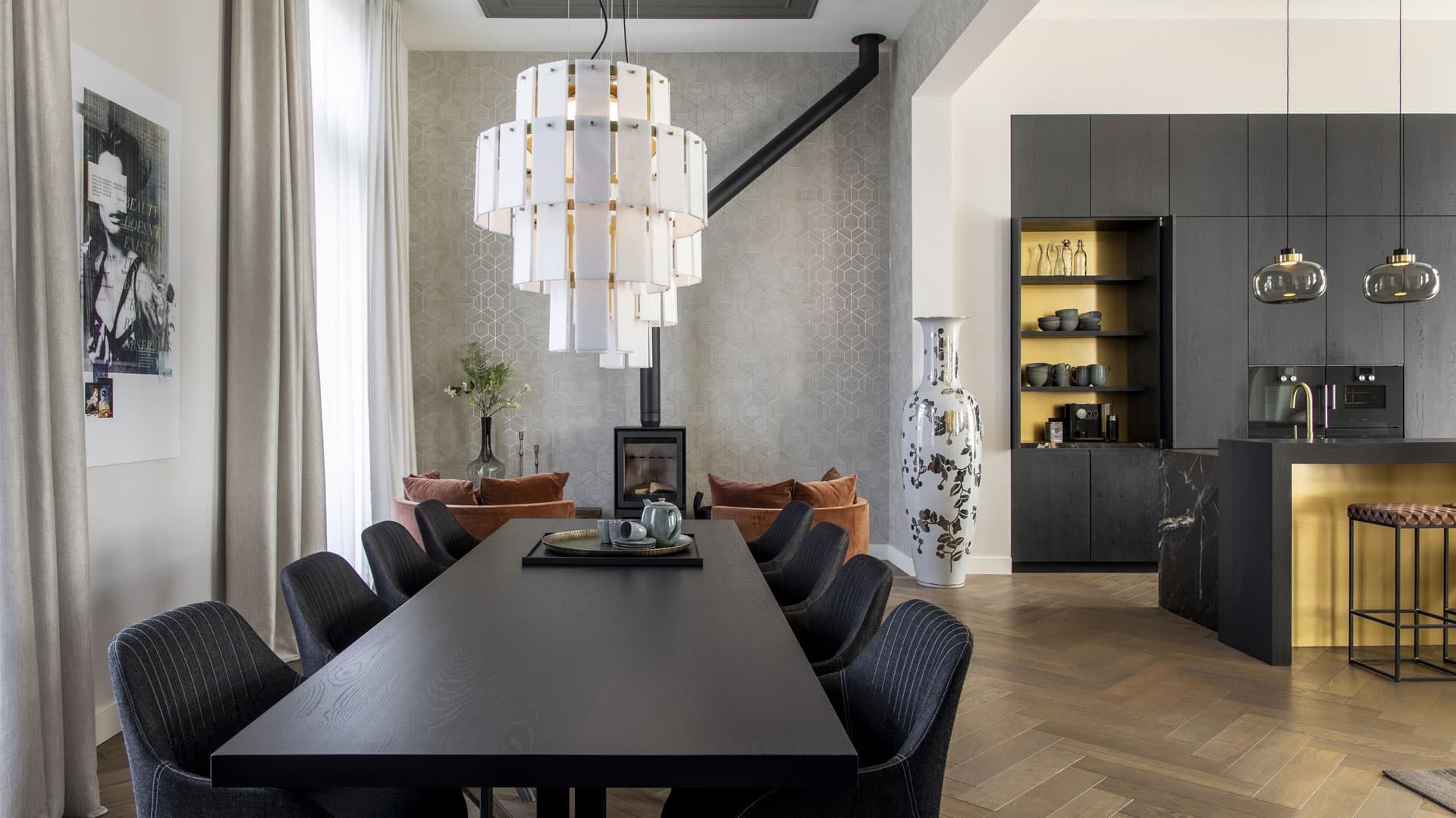 Eetkeuken met zwarte lange tafel, zwarte stoelen en hangende glazen lampen