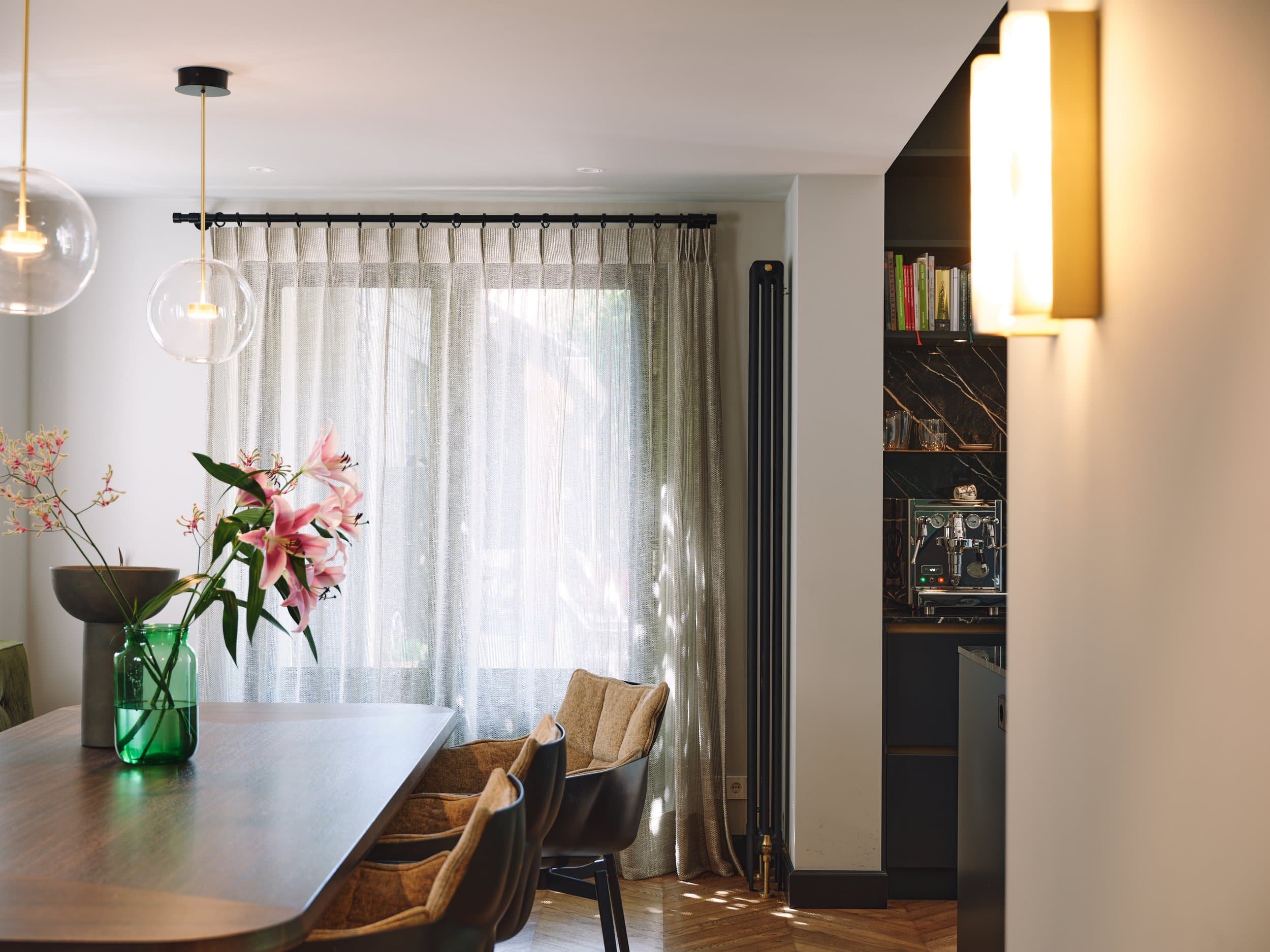 Badkamer met travertijn wanden, zwarte plafondplaten en betonvloer