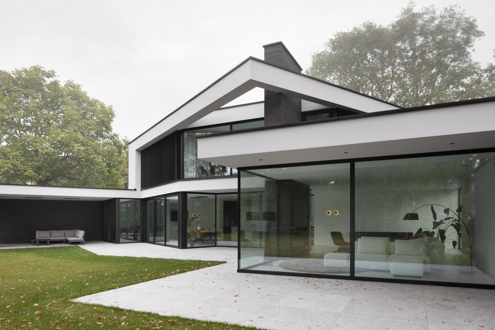 Hedendaagse woning met zwart houtwerk, witte accenten en grote glazen schuifpuien