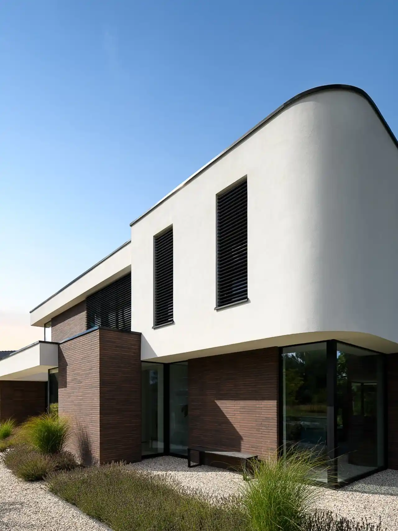 Buitengevel met bakstenen accenten, gevelbekleding en grote raamopeningen