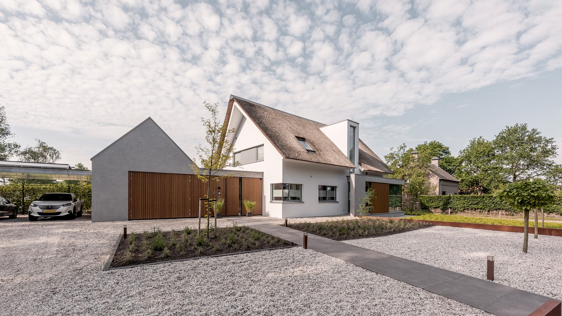 Moderne villa met dubbele garage, houten deurkozijn, rietgedekt dak