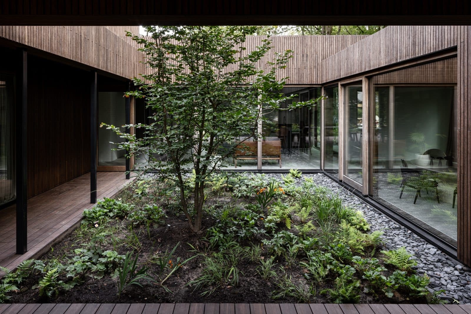 Binnenplaats moderne villa met grind en centrale boom