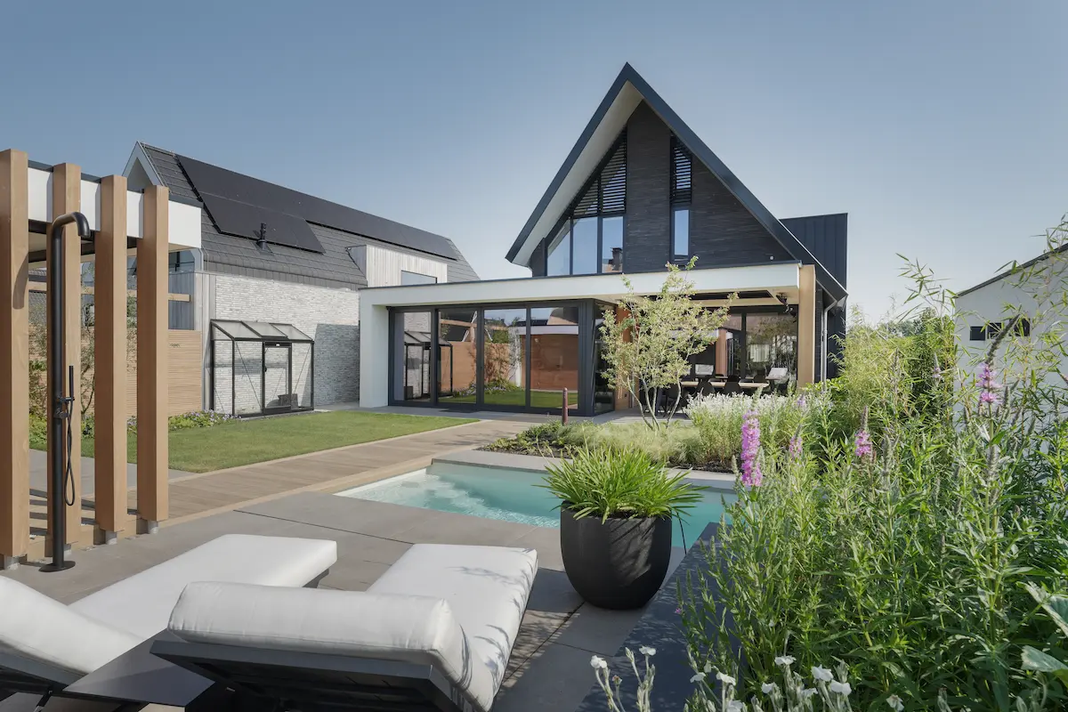 Terras met loungezetel, zwembad en pergola met lamellen