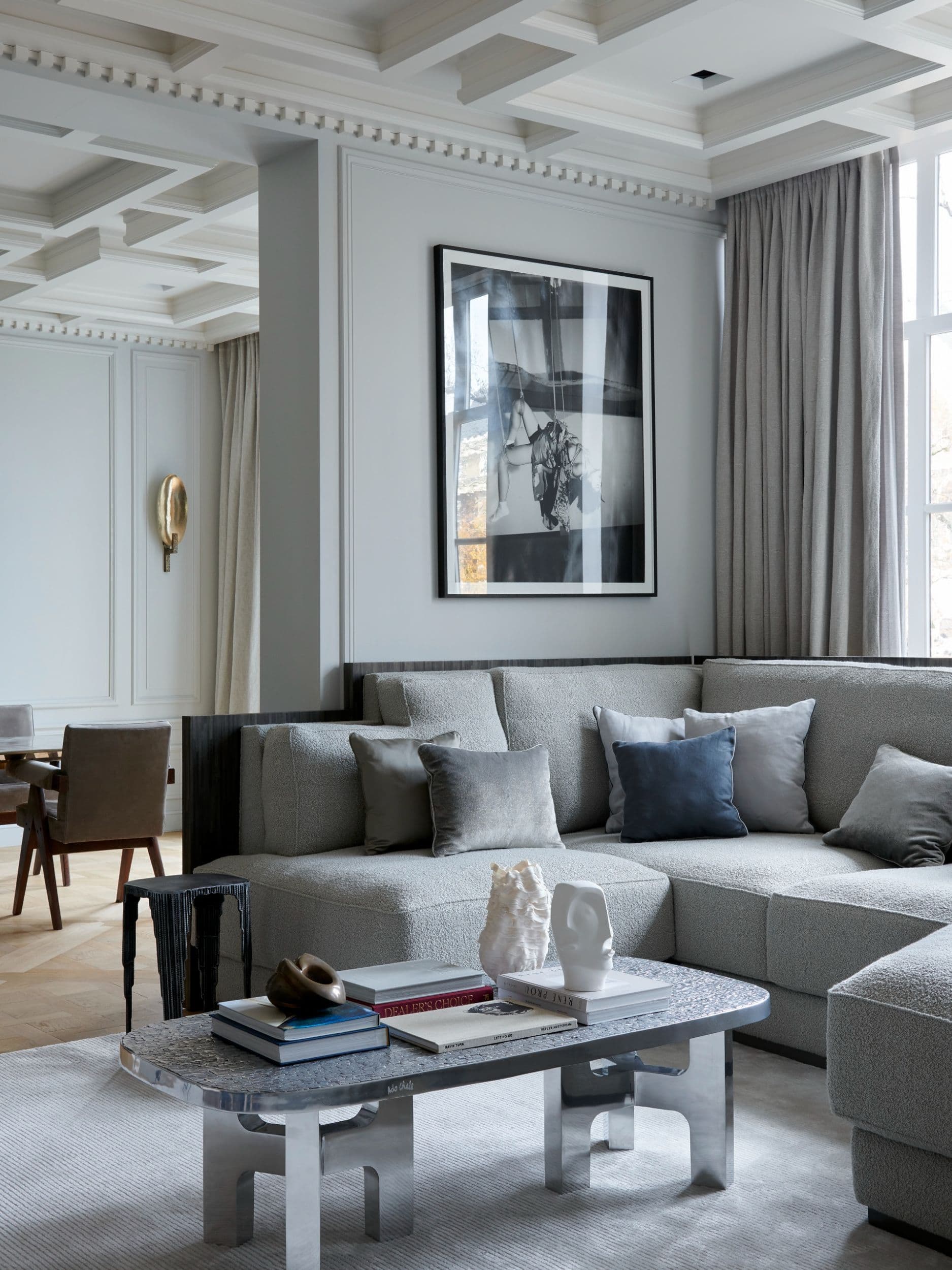 Woonkamer detail met grijze sofa, marmeren tafel en wandschilderij