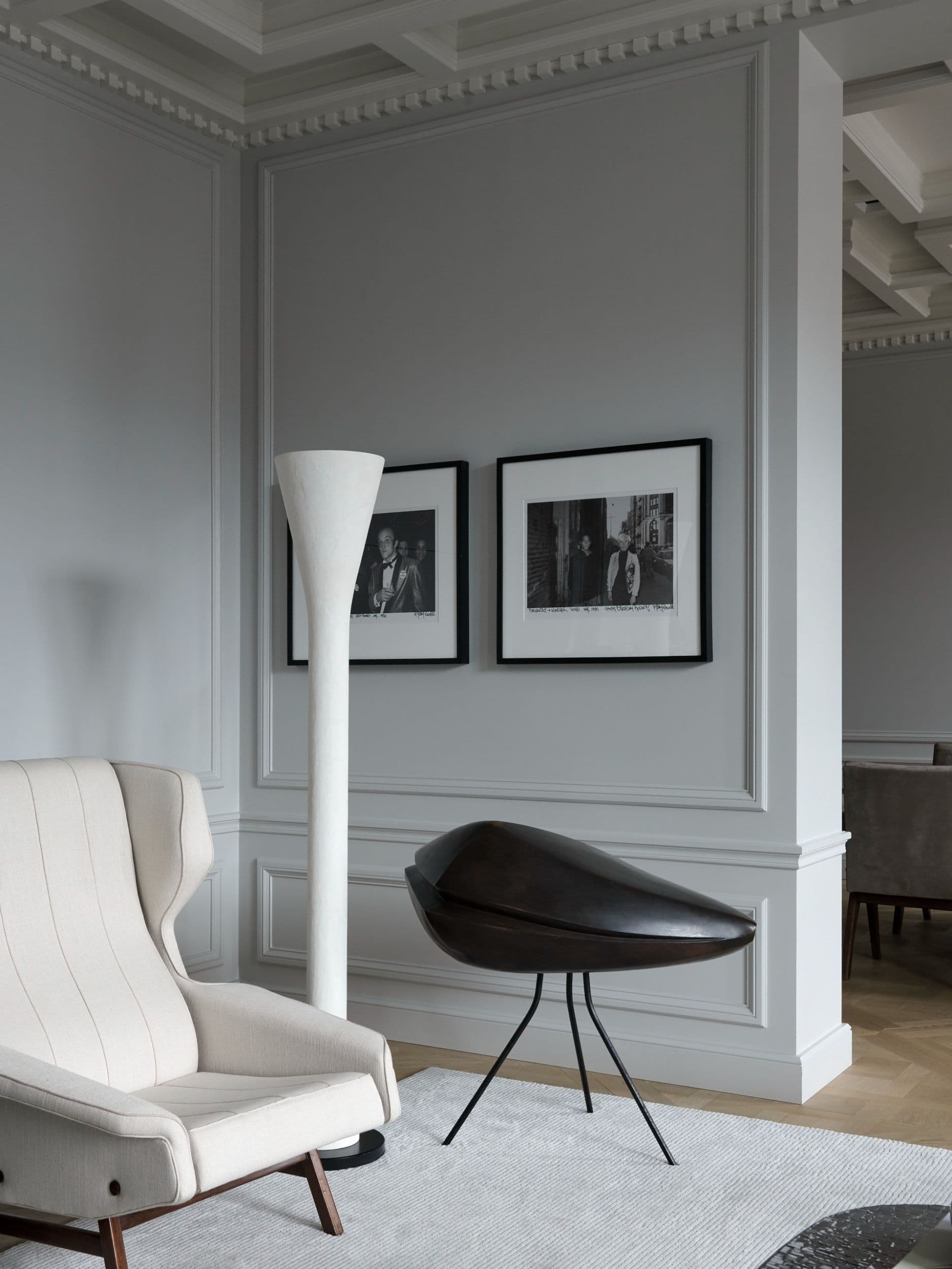 Eetkamer met zwart-wit kunstwerk, donkere stoelen en marmeren tafel