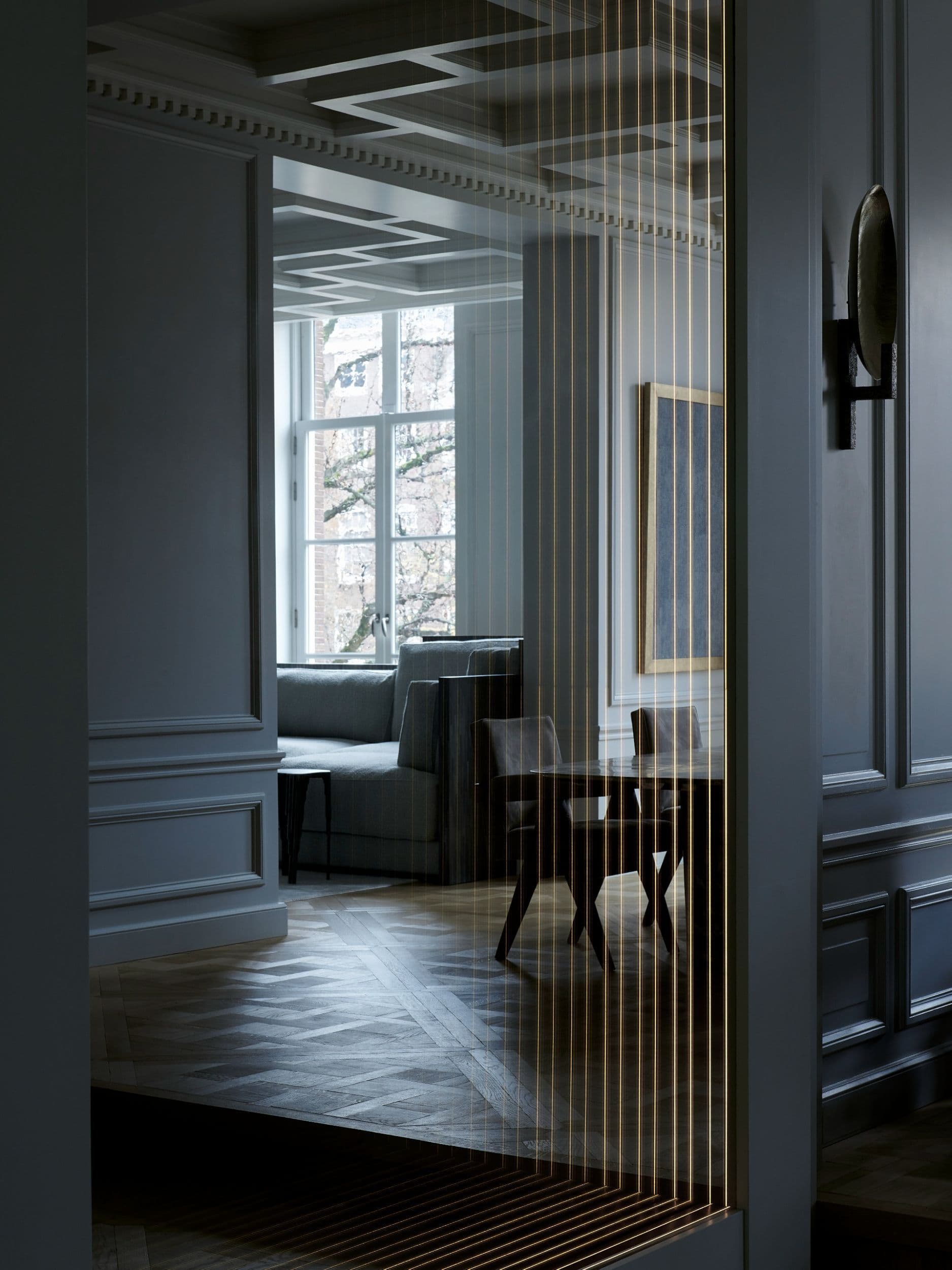 Ingangshal met marmeren blok, witte decoratie en gouden rasterwerk deur