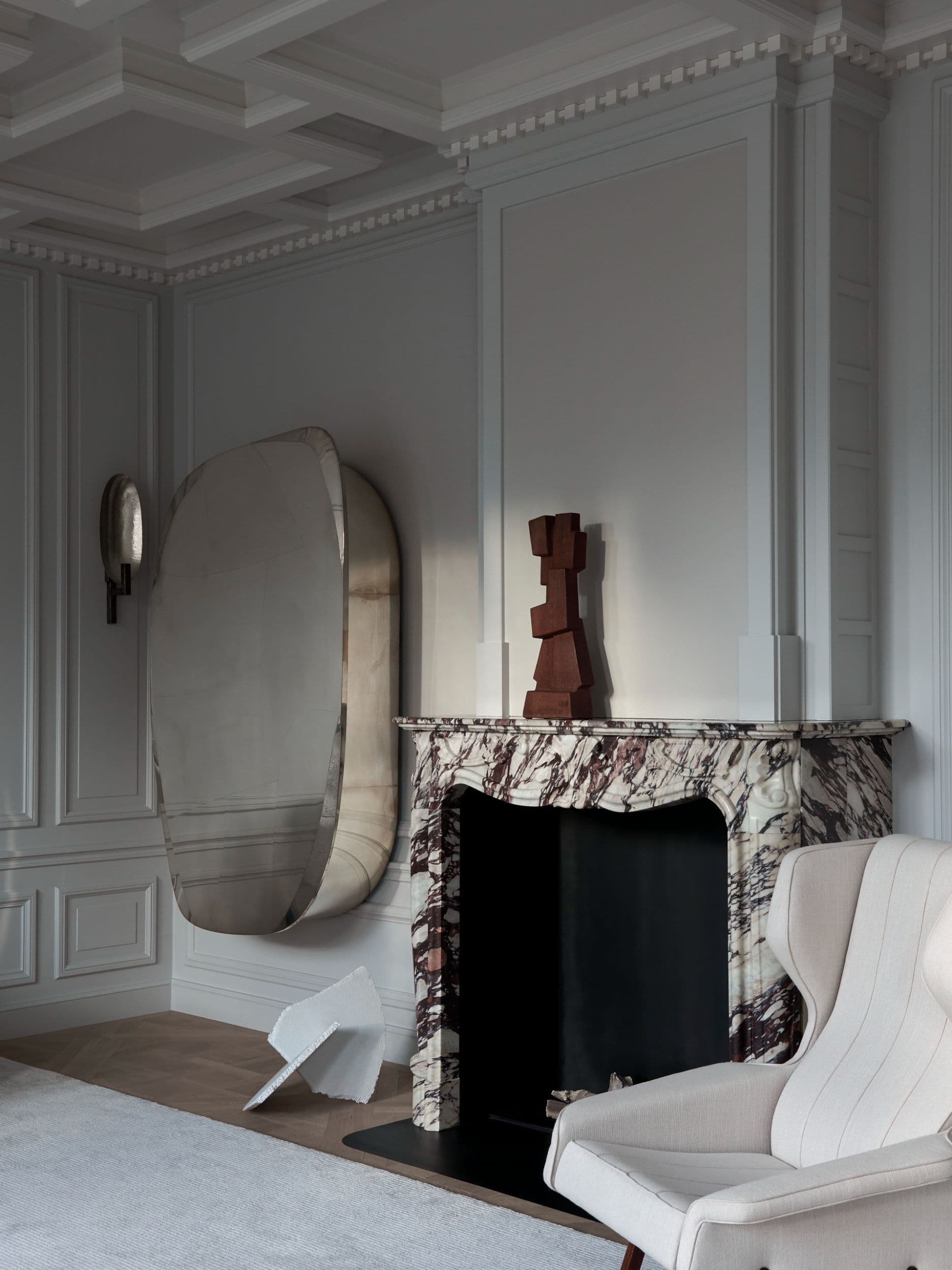 Woonkamer hoek met witte fauteuil, zwarte decoratieve stoel en panelwanden
