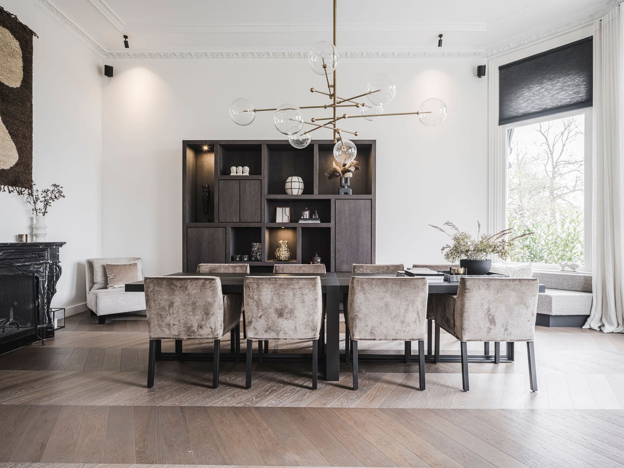 Eetkamer met zwarte houten kasten en zithoek