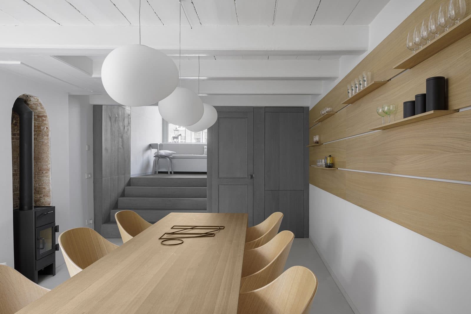 Woonkeuken met houten tafel, beige stoelen en zwarte hanglamp