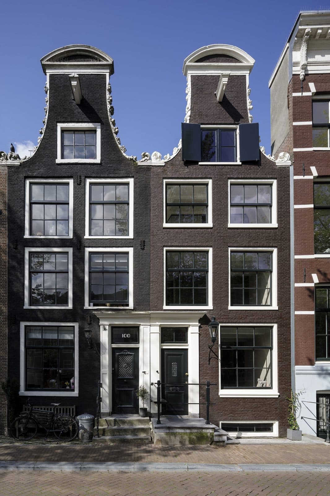 Amsterdamse grachtenpand donkerbruin bakstenen gevel, karakteristieke dakkapel