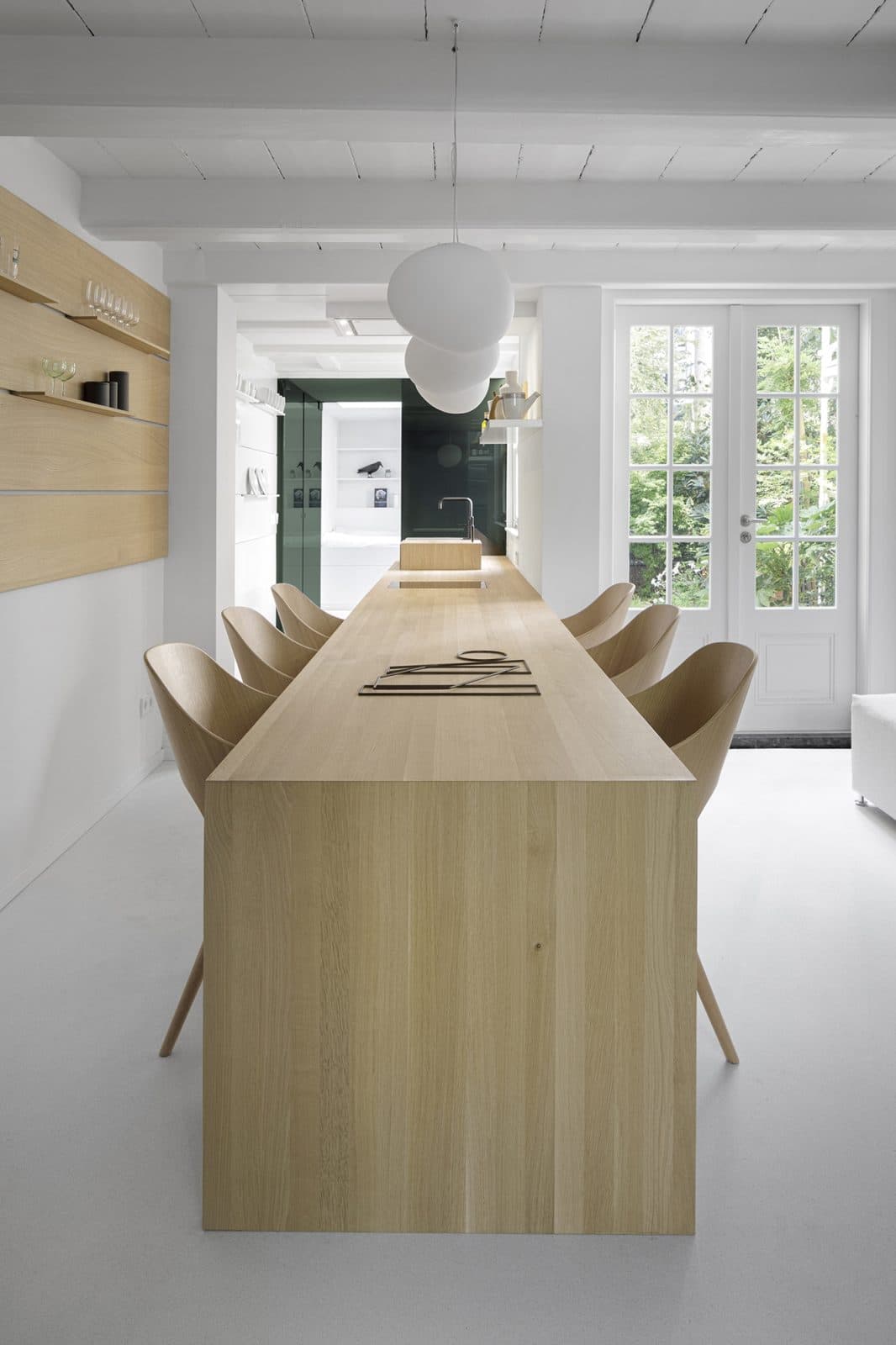 Eetkeuken met houten tafel, beige stoelen en witte hanglamp