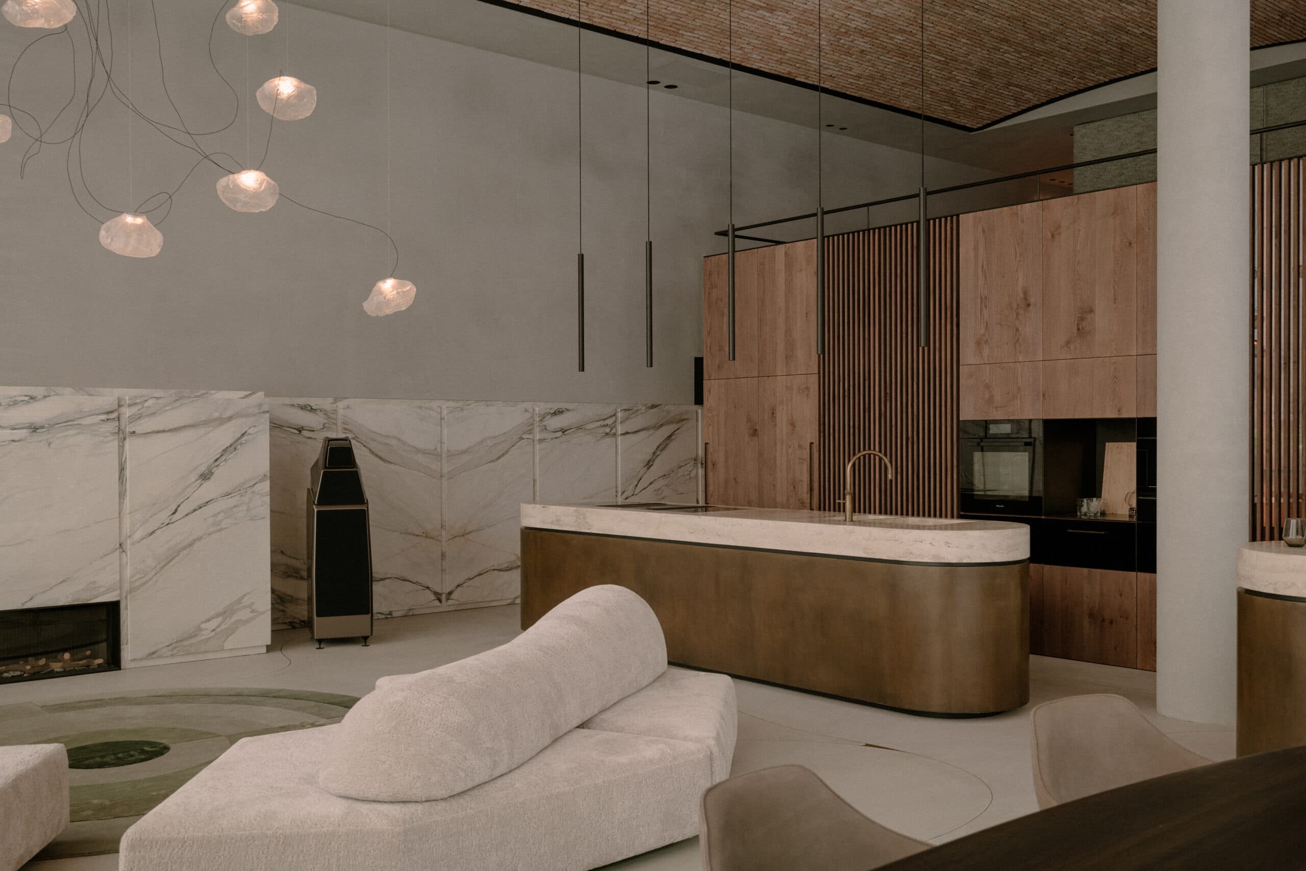 Wellness ruimte met marmer wanden, grijze zitmeubels en hangende verlichting