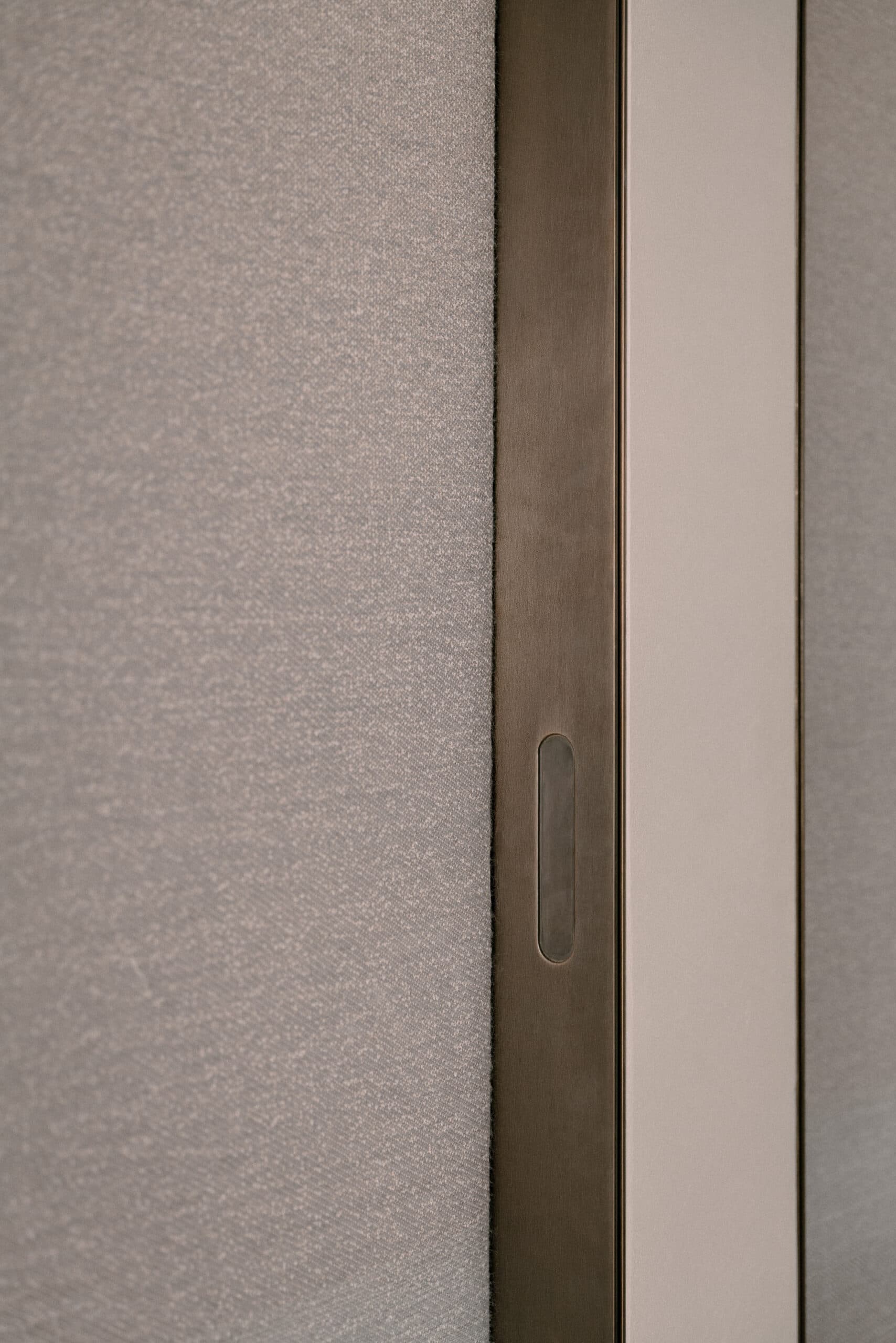 Detail deurkruk en linnen wandpaneel in neutrale tinten