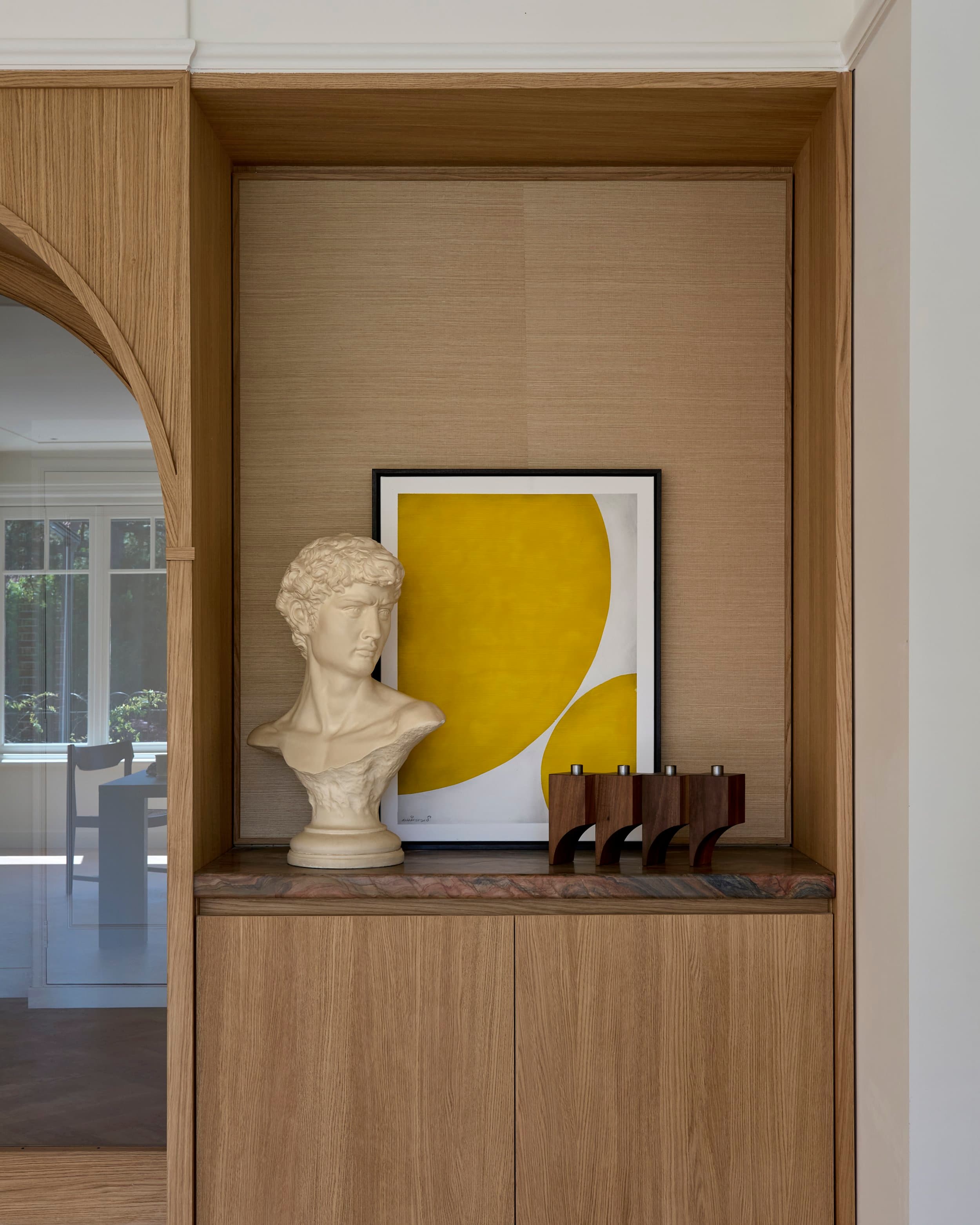 Eetkamer zicht door eikenhouten boog met ronde hanglamp