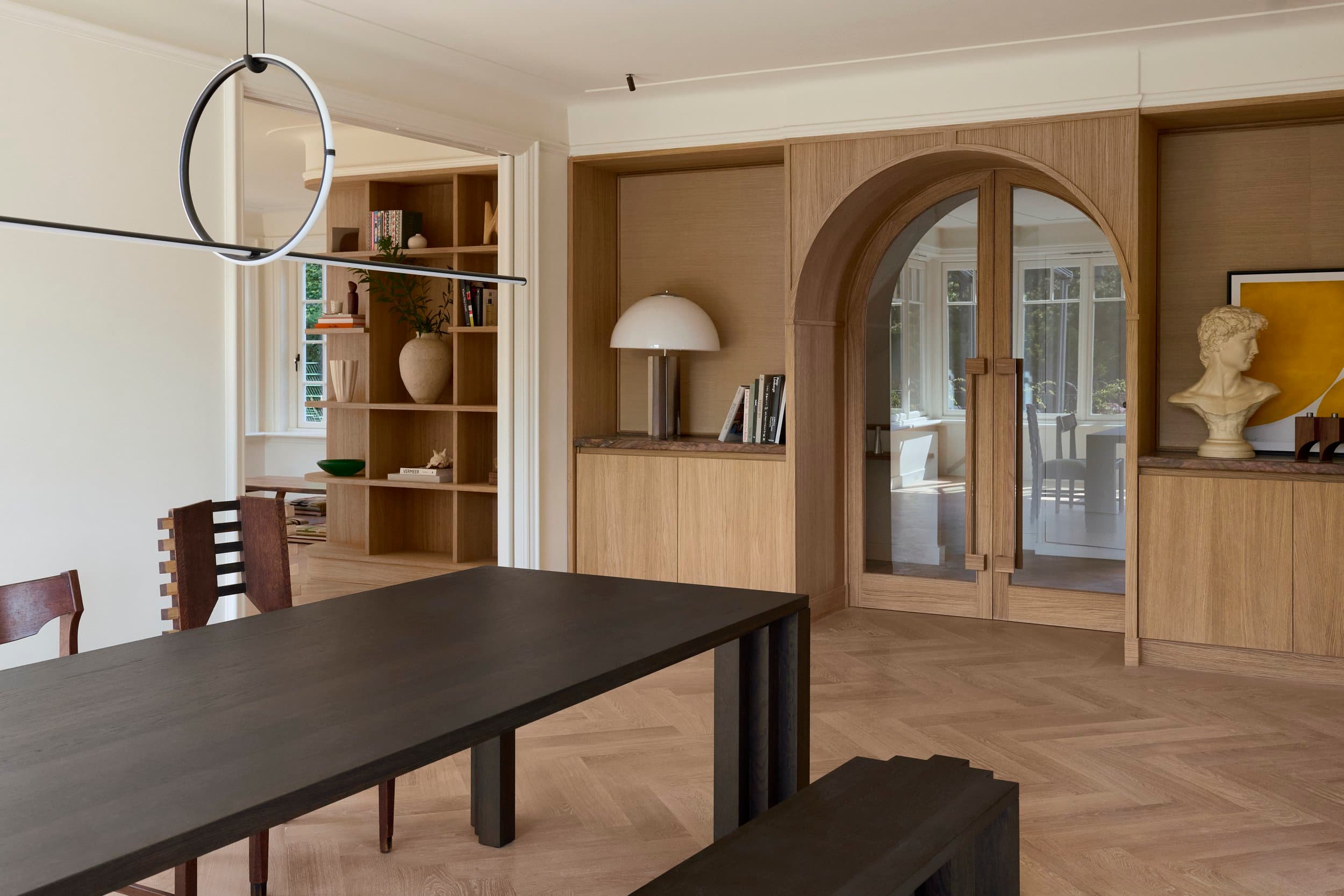 Woonruimte met eikenhouten kastenwand en ronde boogdeur