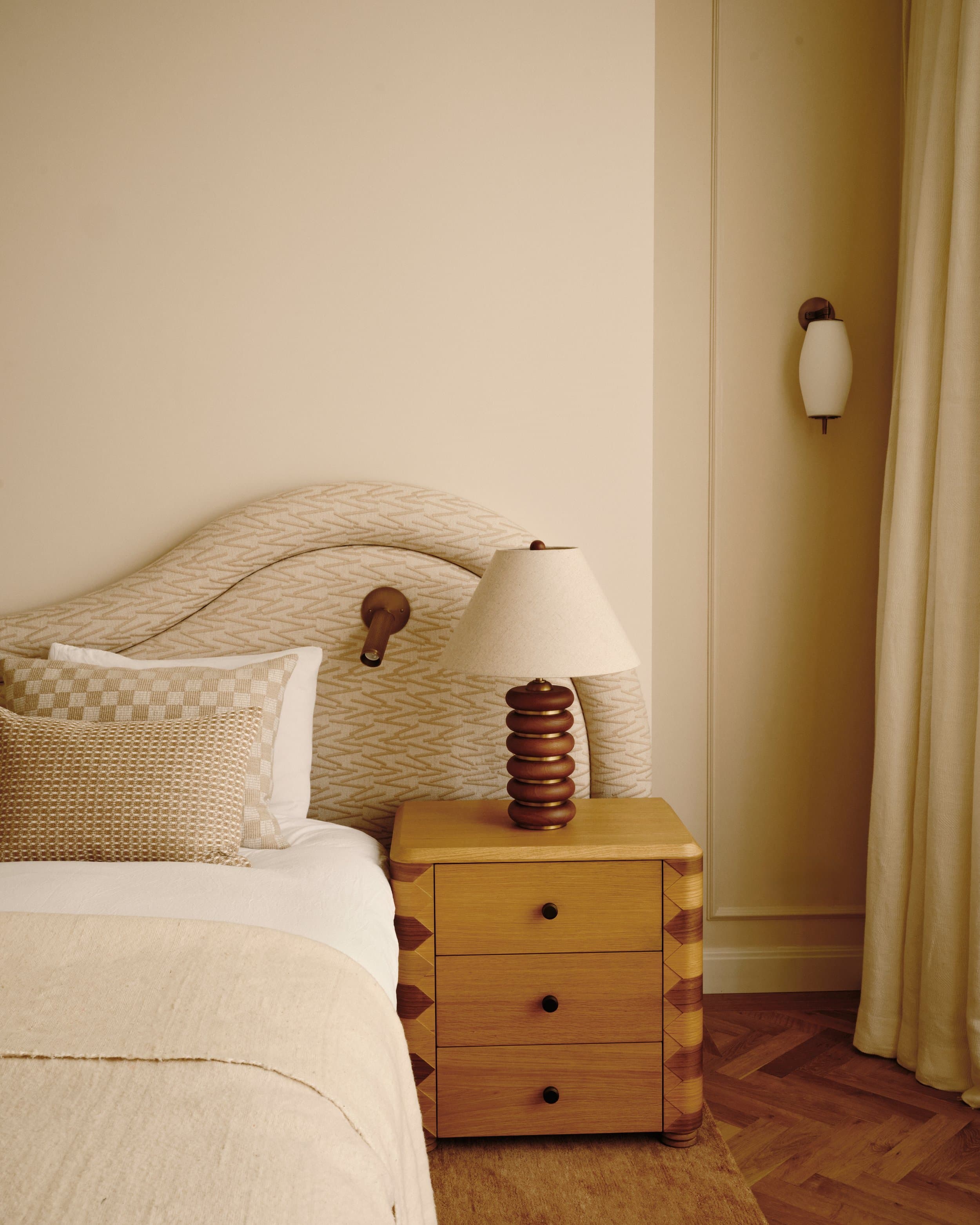 Sober slaapkamer met houten nachtkastje, beige bedlinnen en gemarmerde details