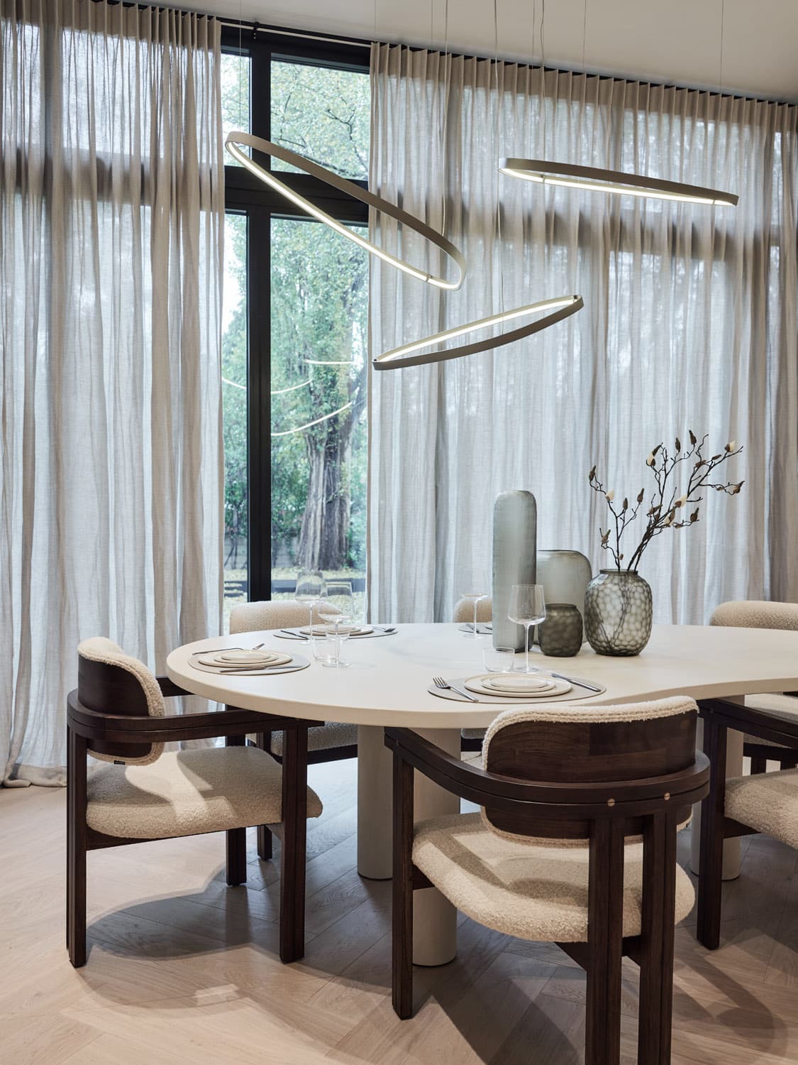 Moderne eetkamer met ovalen eettafel, houten stoelen en hanglampen