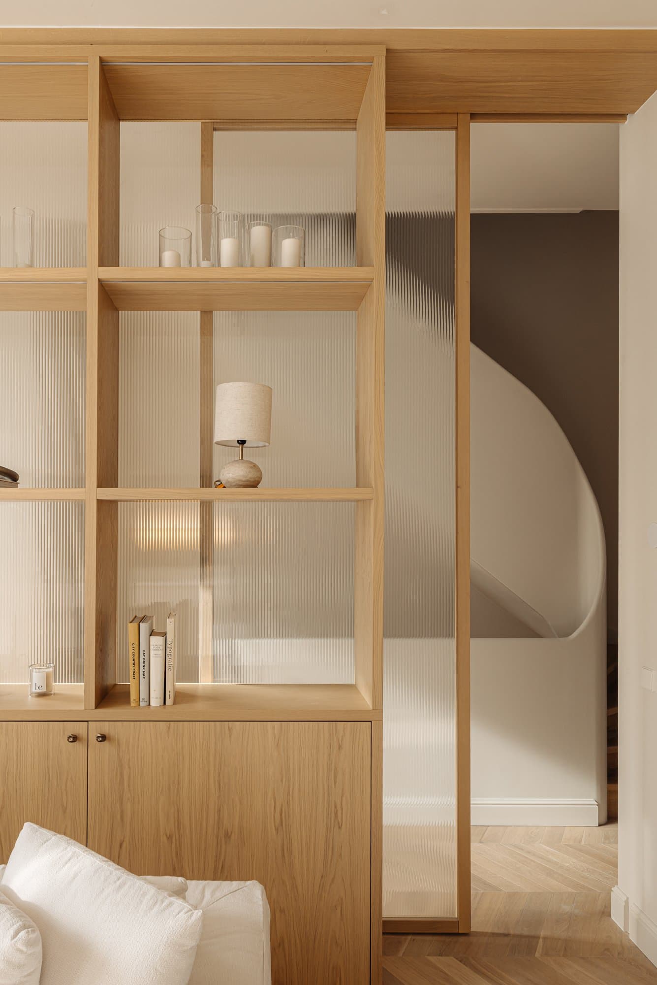 Woonkamer met eikenhouten boekenkast en geribbeld glas