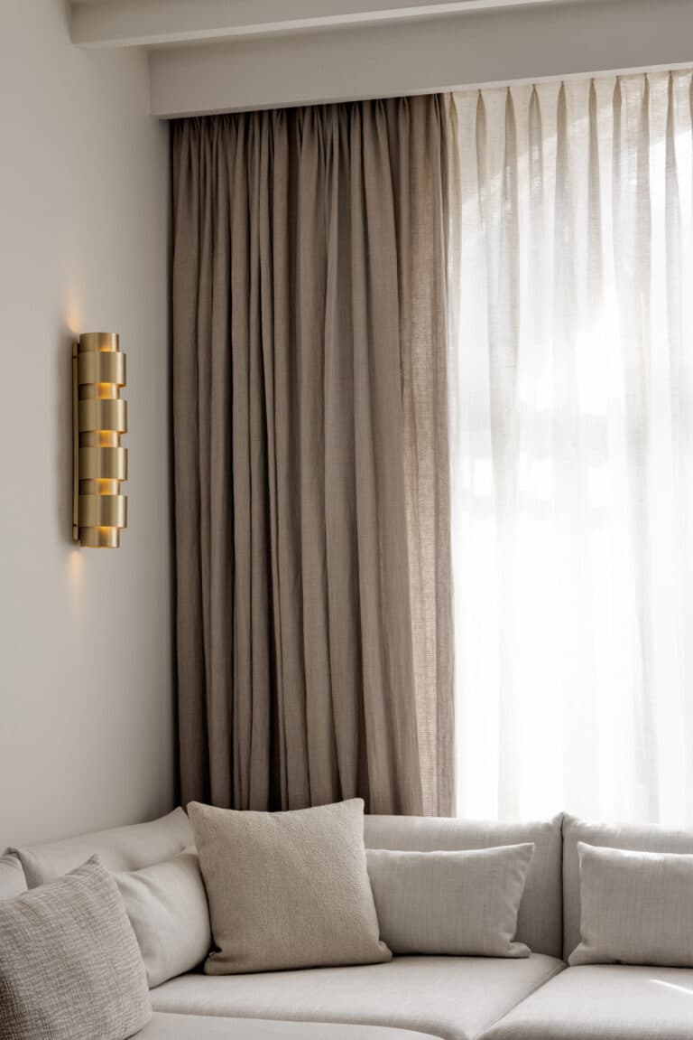 Woonkamer met gashaard, beige zitbank en zwarte salontafel