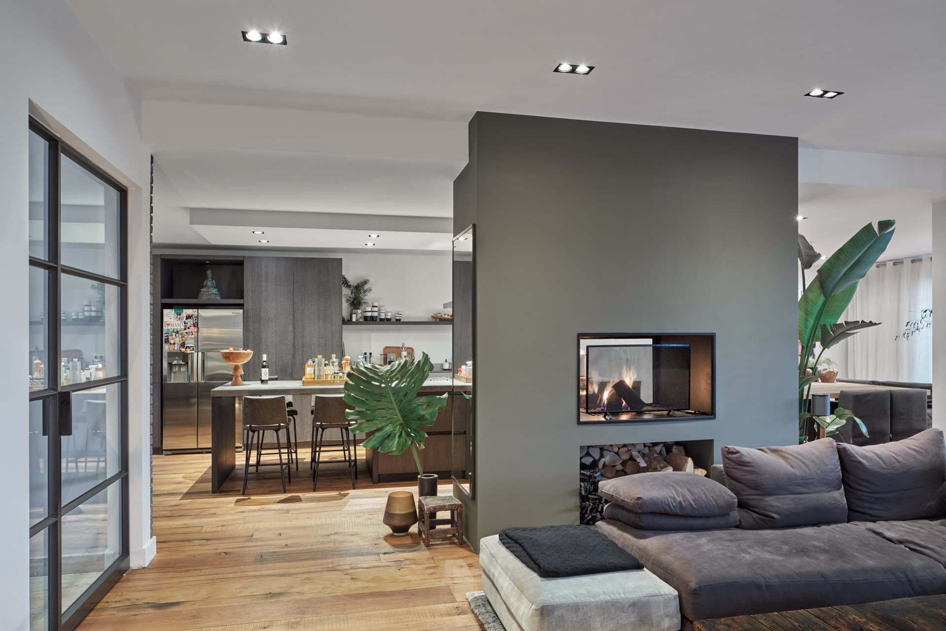 Woonkamer met grijze accent wall, ingebouwde haard en houten vloer