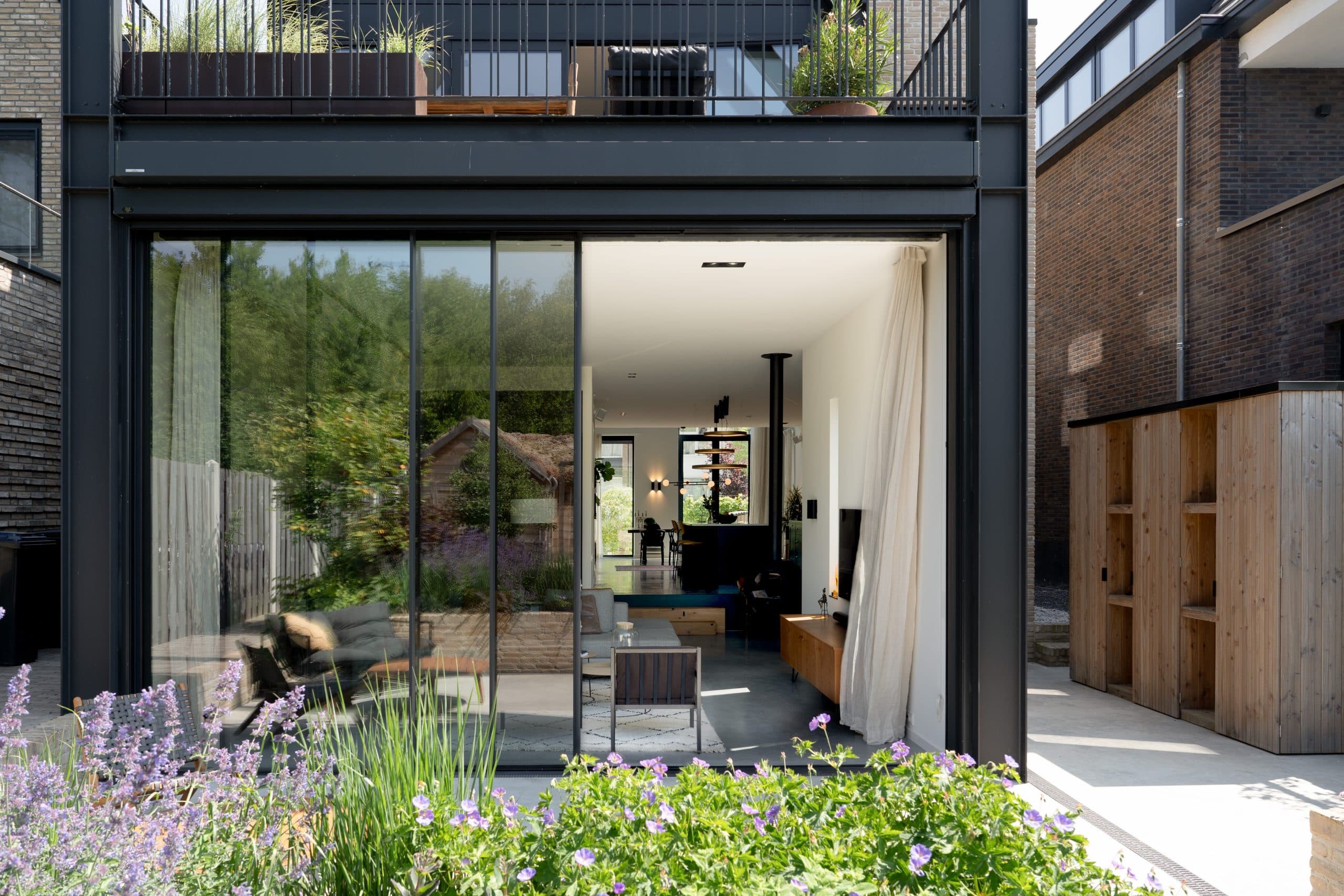 Moderne houten pergola met zwarte bbq-unit, waterzicht, terras