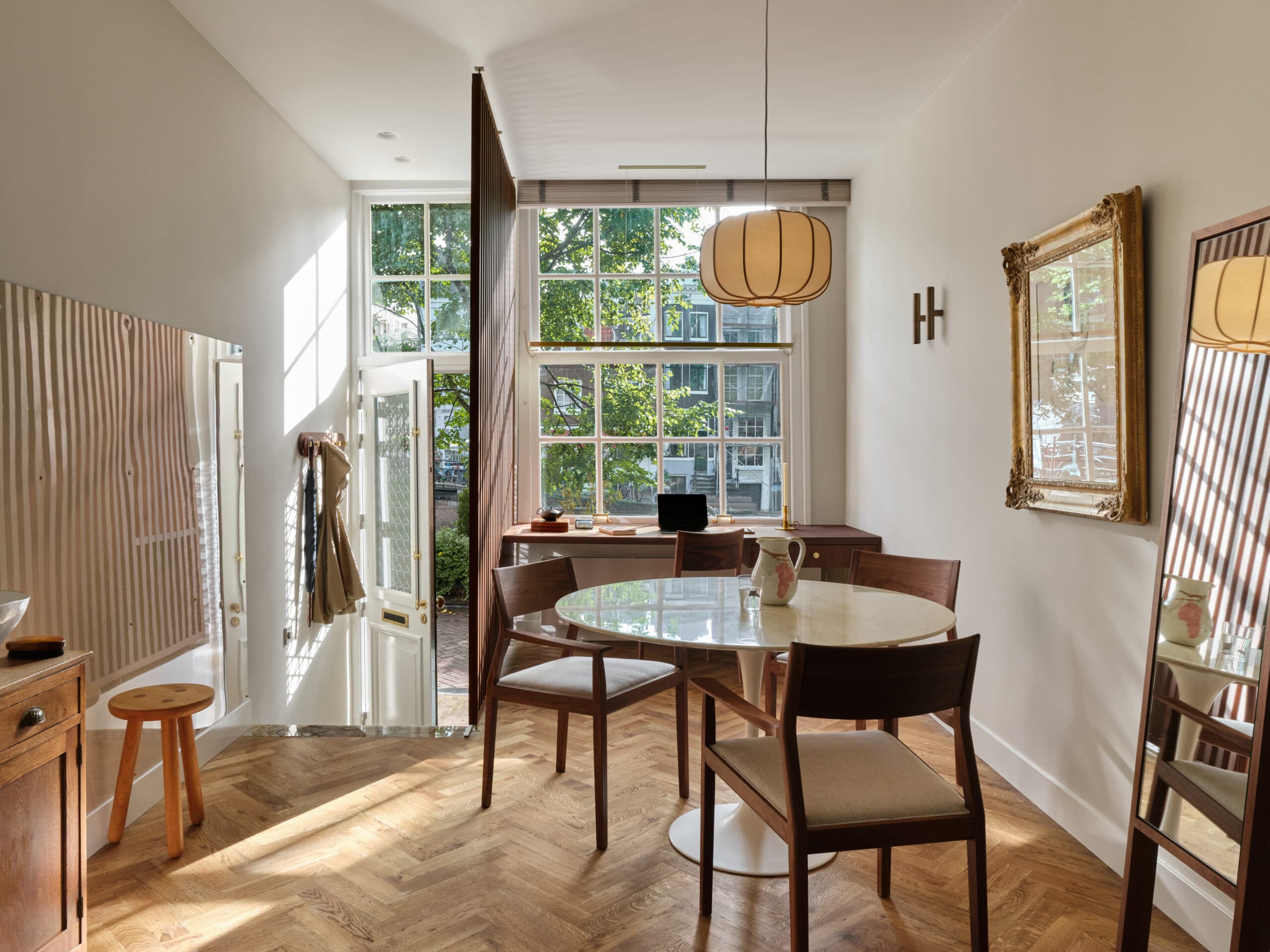 Eetkamer met rond marmerblad tafel en vintage houten stoelen