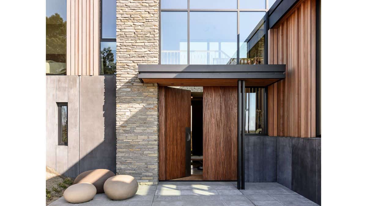 Moderne villa met houten gevelbekleding en stenen ingangspartij