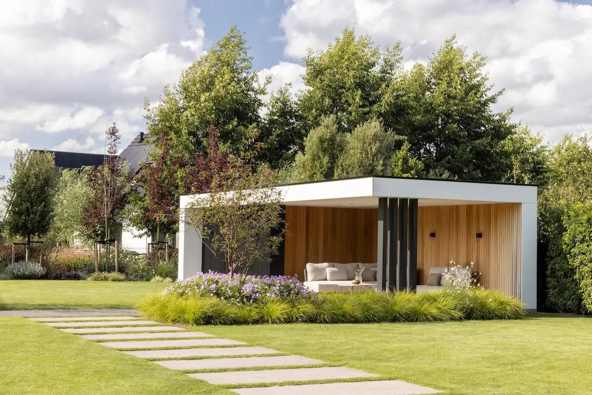 Moderne tuinpaviljoen met witte gevels en houten interieur