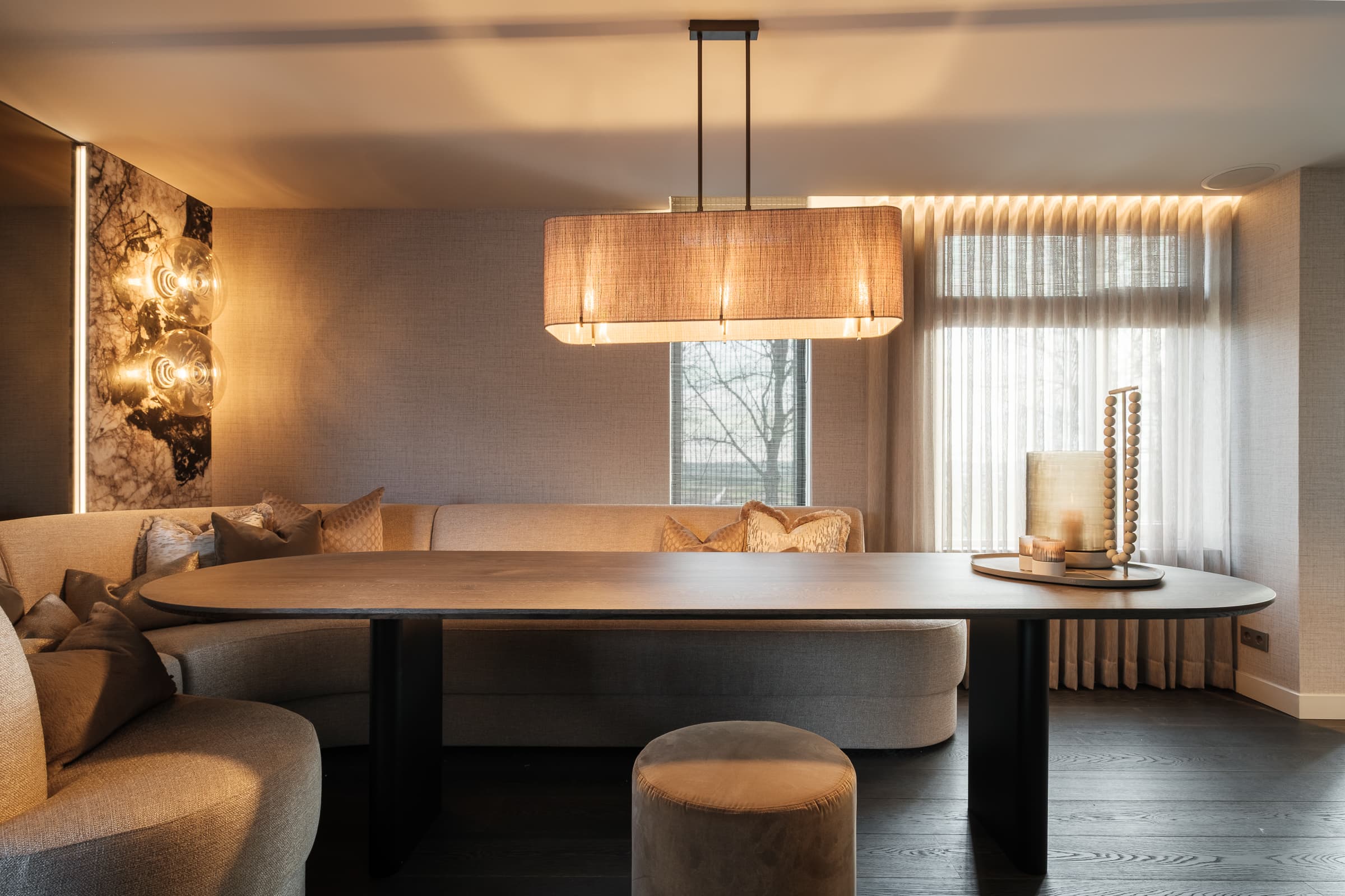 Woonkamer met hoekbank, TV en kunstwerk aan muur
