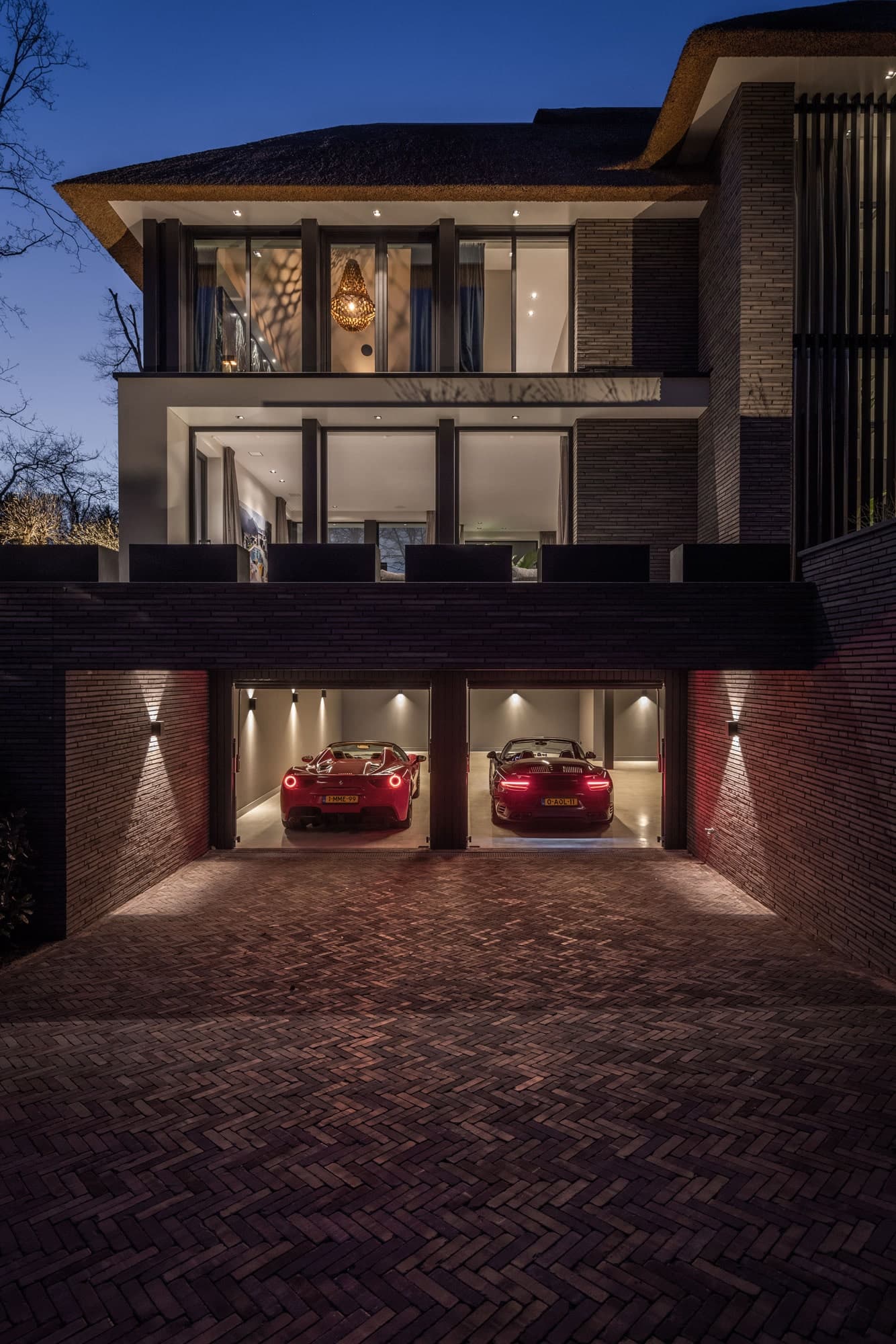 Moderne villa met baksteengevel, garage en verlichte voorgevel