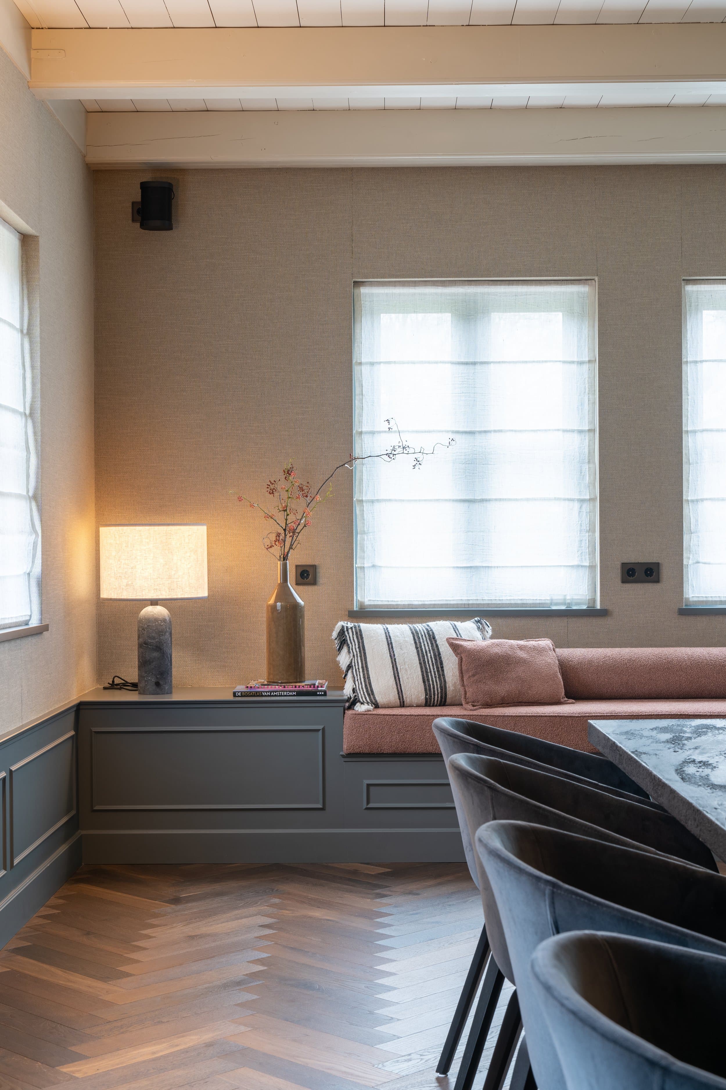 Eetkamer met zwart marmeren tafel, leren stoelen en glazen deuren