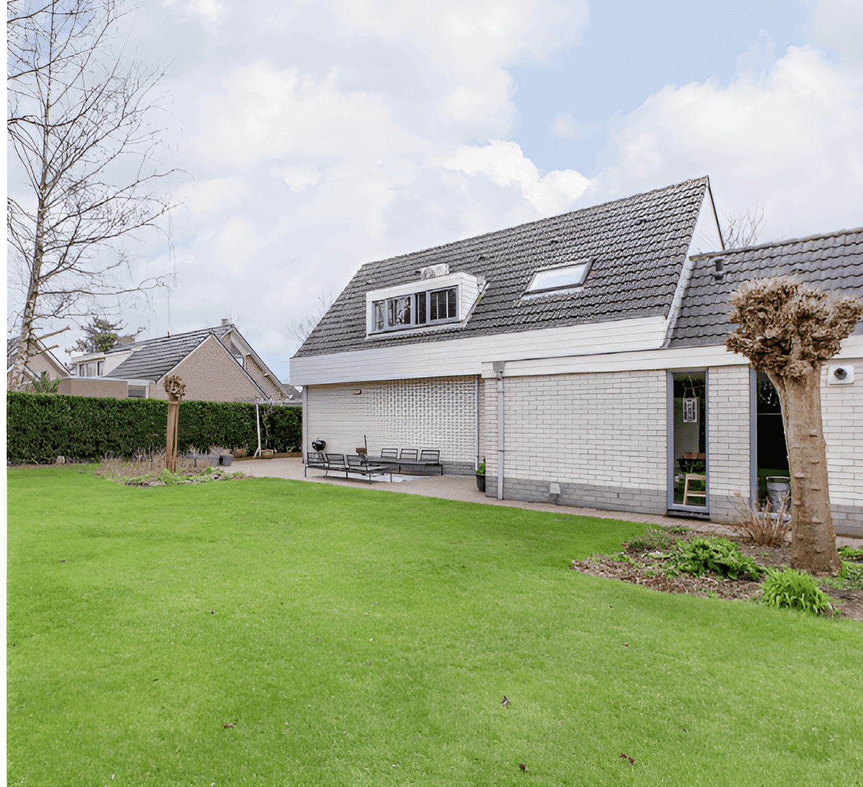 Witte villa met leisteen dak en grote gazon landschap
