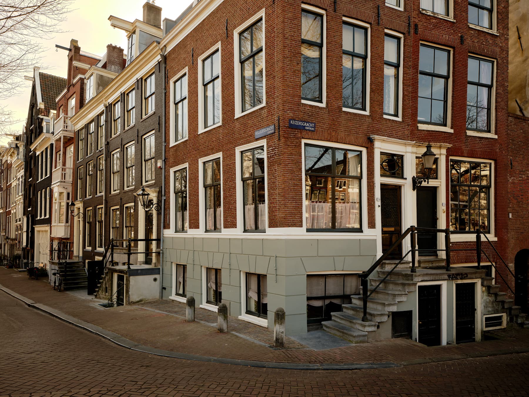 Gevelfront met rode bakstenen, witte steenlijsten en grote ramen