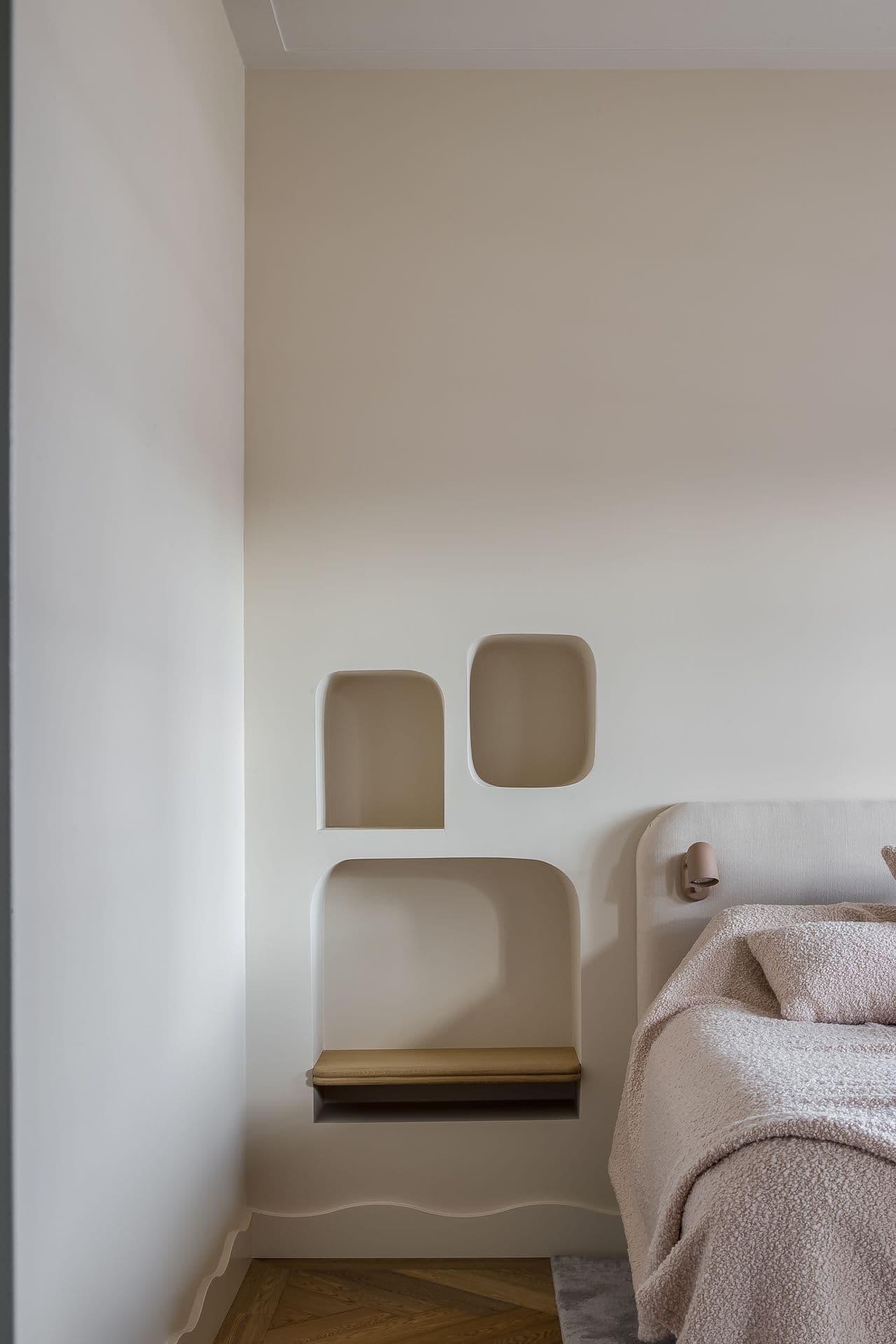 Slaapkamer met ingebouwde houten nis en beige linnen bedkleding