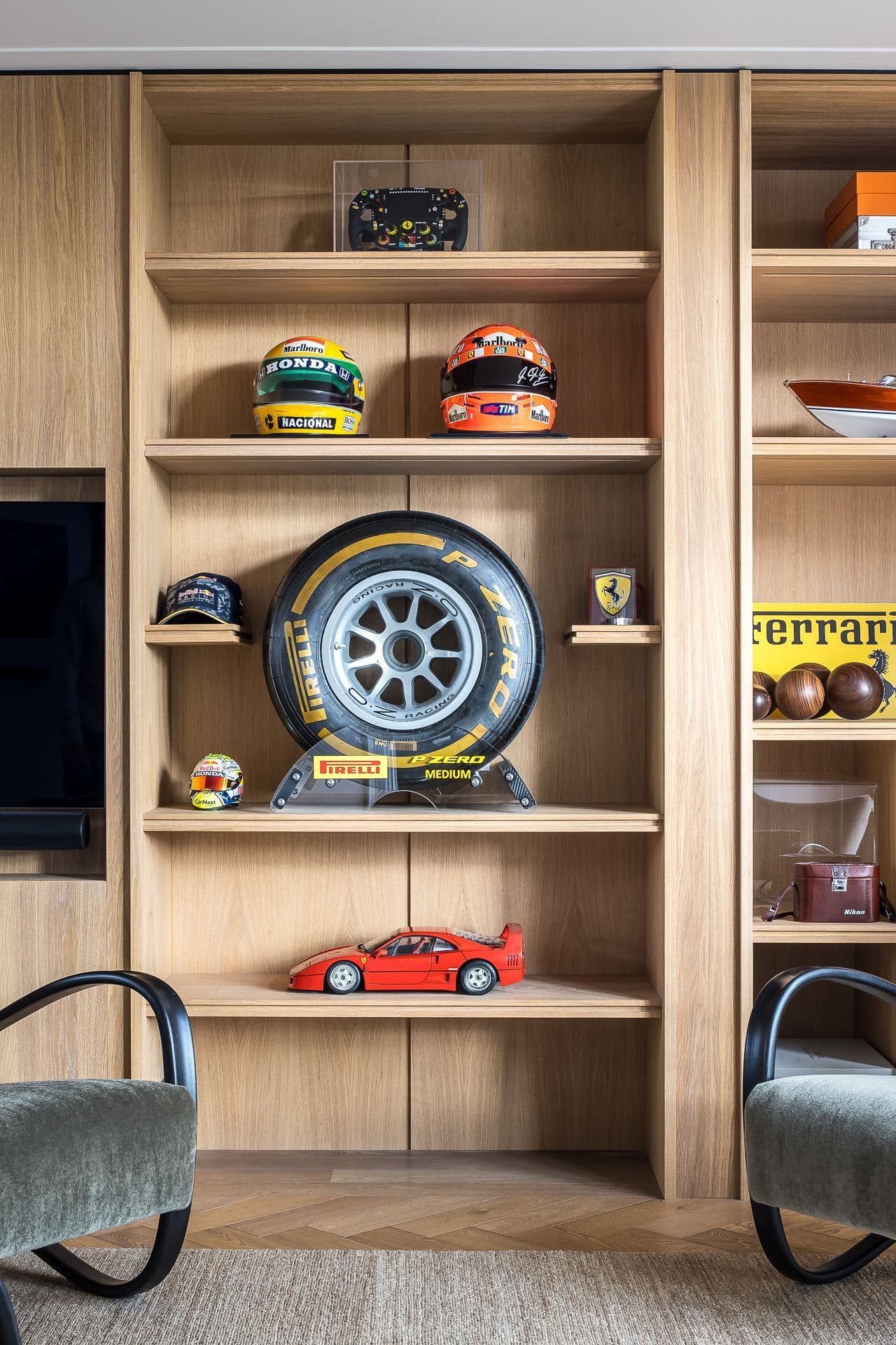 Woonkamer met eikenhouten open boekenkasten, displayobjecten en grijze stoelen