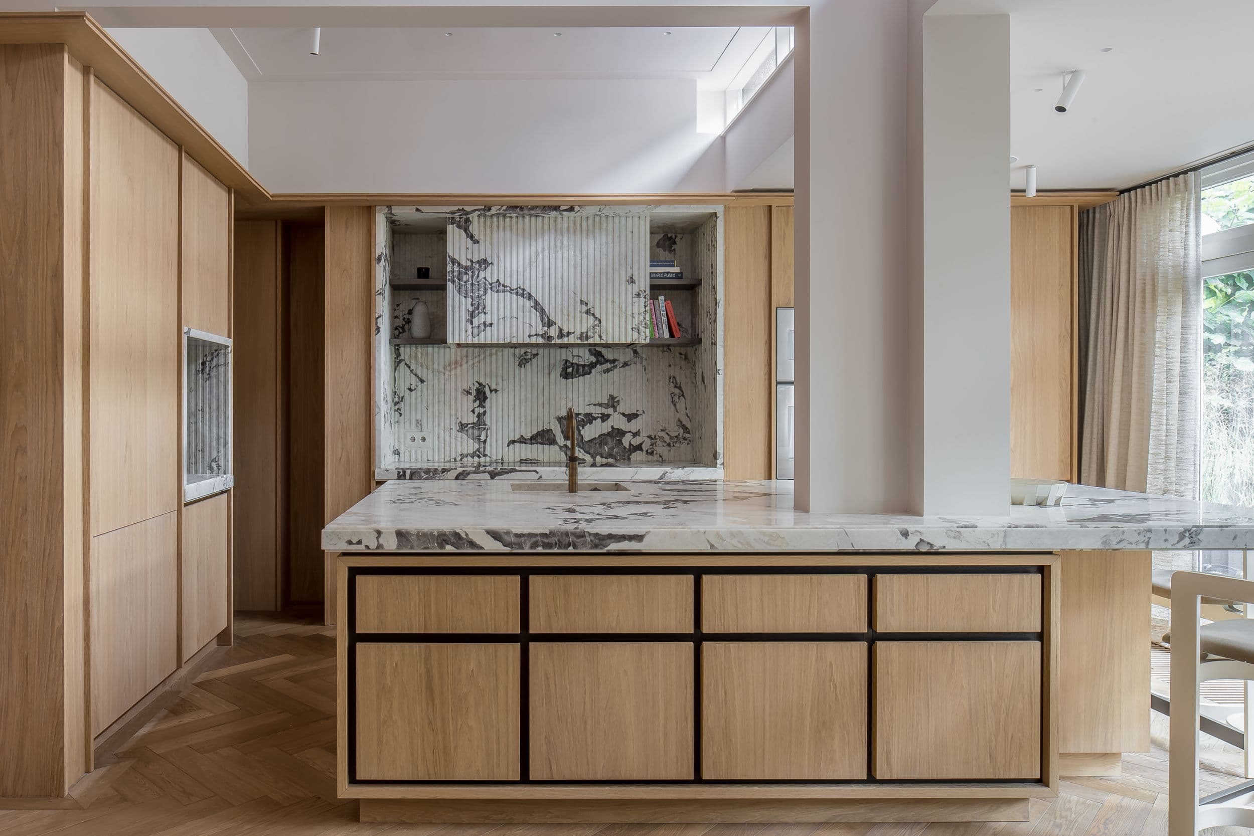 Keuken met eikenhouten kastenwand, marmeren werkblad en zwarte frame kastjes